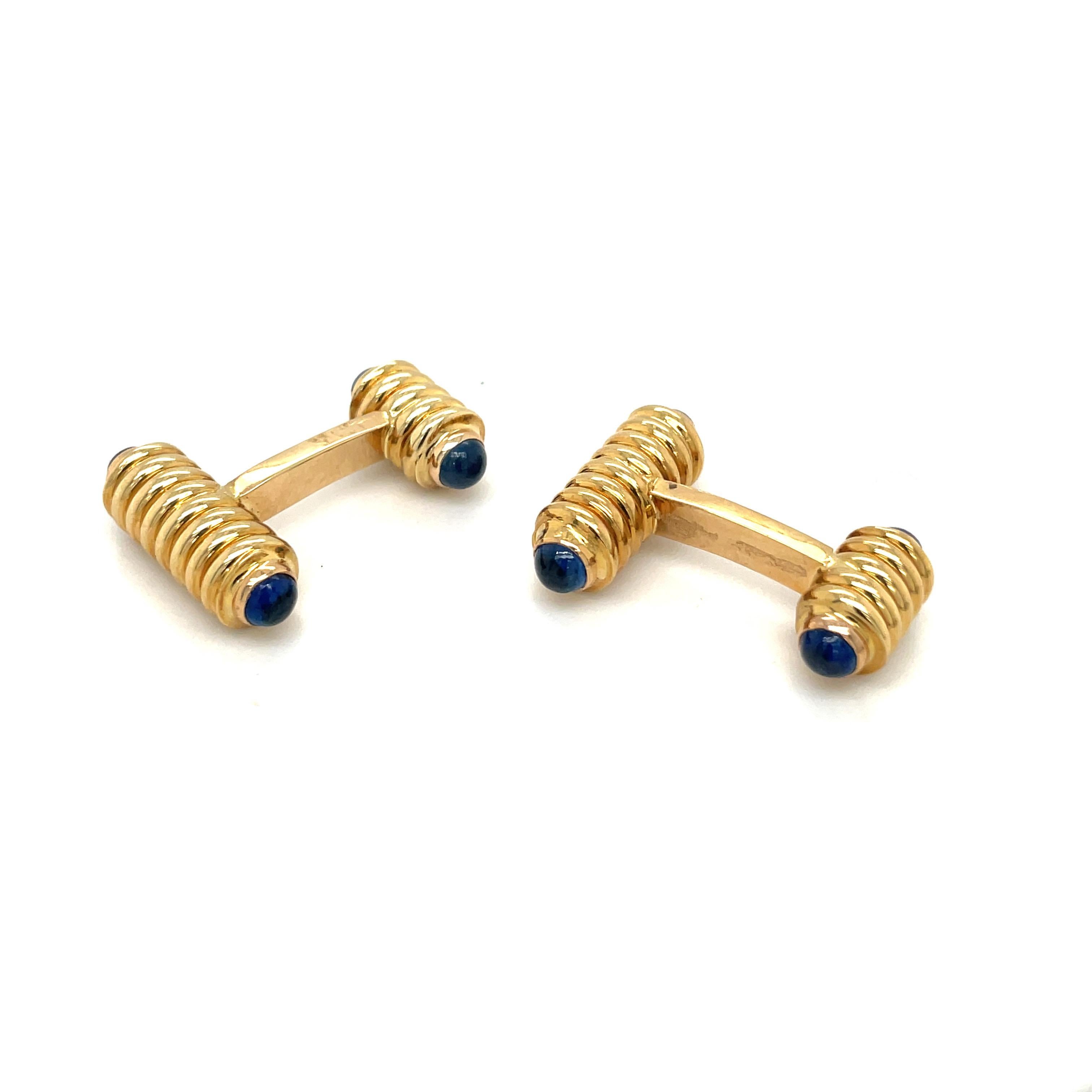 Classic bar style cuff links in 18 karat yellow gold. The cuff links are tipped with 4 blue sapphire cabochons. They measure 1
