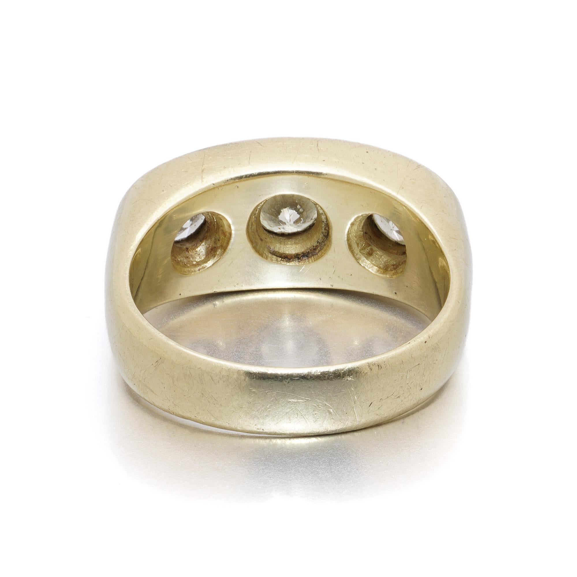 Un audaz y pesado anillo de estilo vintage elaborado en oro amarillo de 18 quilates, engastado con tres diamantes redondos talla brillante en montura enrasada. La banda ancha, ligeramente abombada, es sólida y sustancial, lo que confiere a esta