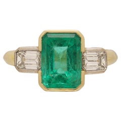 Anillo de oro amarillo de 18 quilates de tres piedras con esmeralda y diamantes