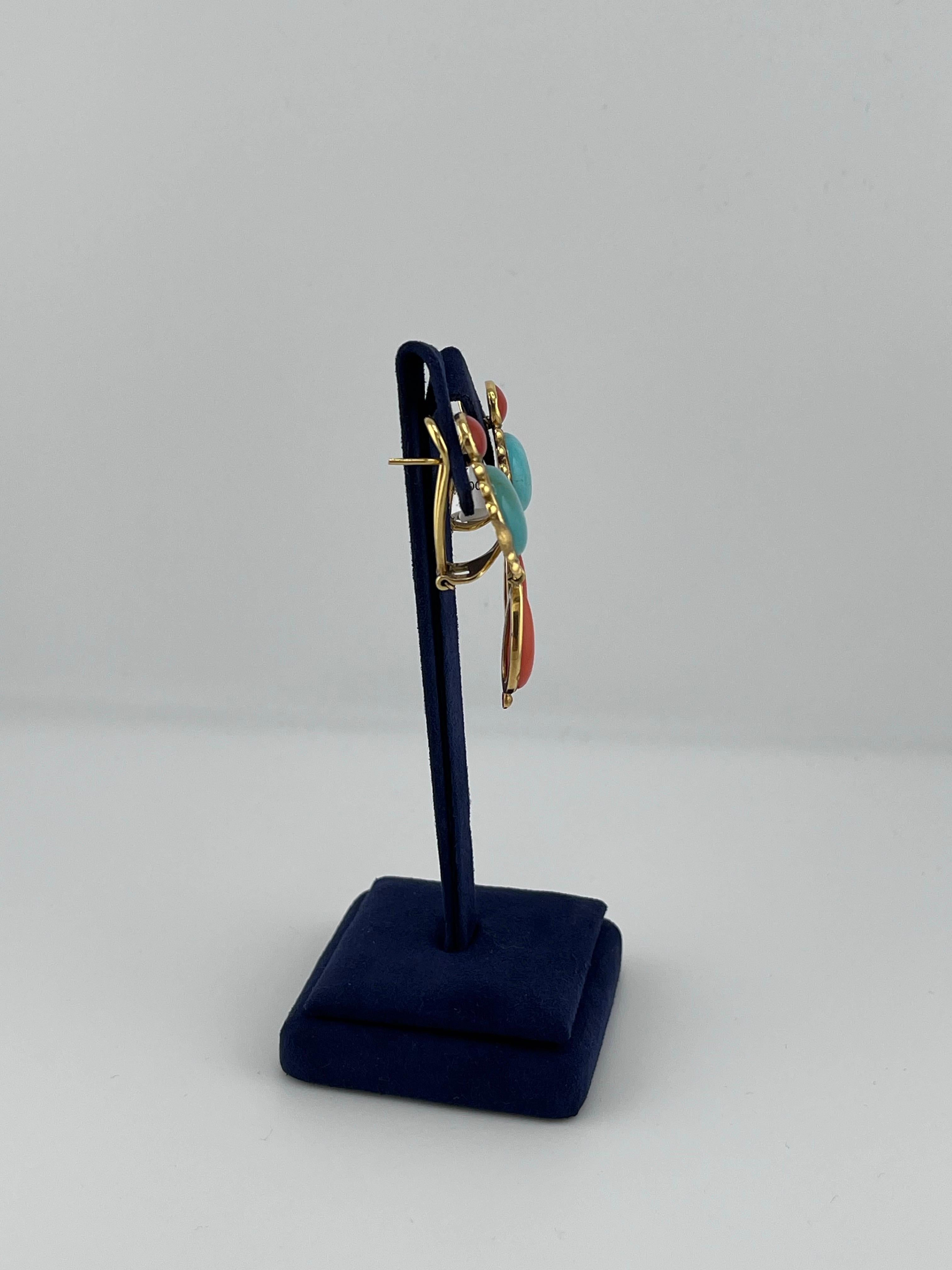 Set into 18kt yellow gold are 2 highly polished pinkish coral cabochons, 2 highly polished red coral cabochons, and 2 highly polished blue turquoise cabochons. This pair of earrings features a highly polished finish and a matte finish to provide a