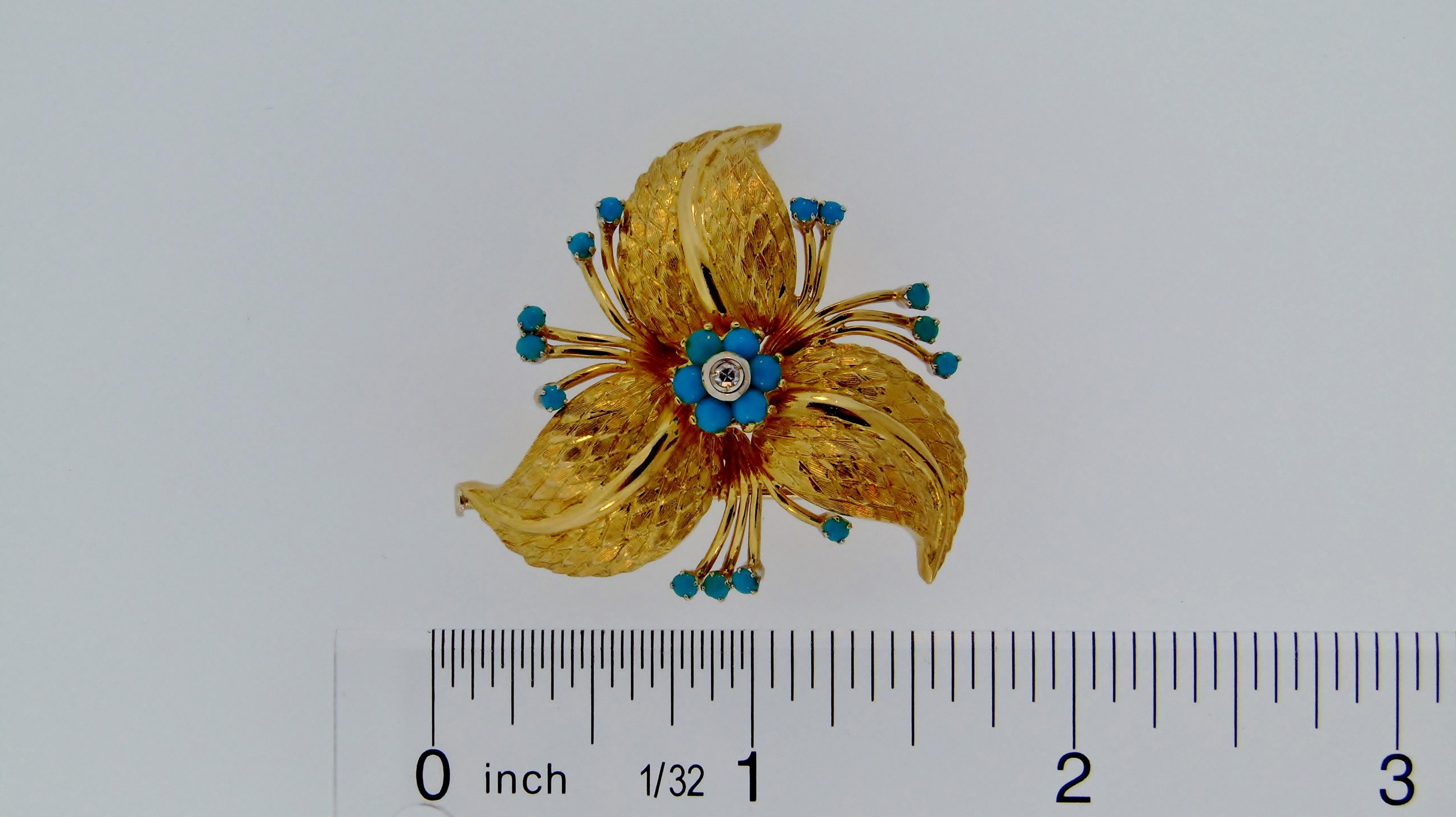 Hand crafted 18 karat yellow gold foliate motif brooch composed as three intricately textured leaves centered by one (1) single cut diamond surrounded by six (6) turquoise cabochons.  The brooch features an additional fourteen (14) stems each