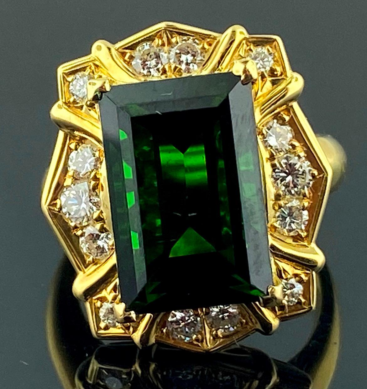 Set in 18 karat yellow gold is a 7.50 carat emerald cut Green Tourmaline center stone, with 14 round brilliant cut diamonds in the surrounding mounting.  Total diamond weight is o.61 carats.  Ring size is 6.25.