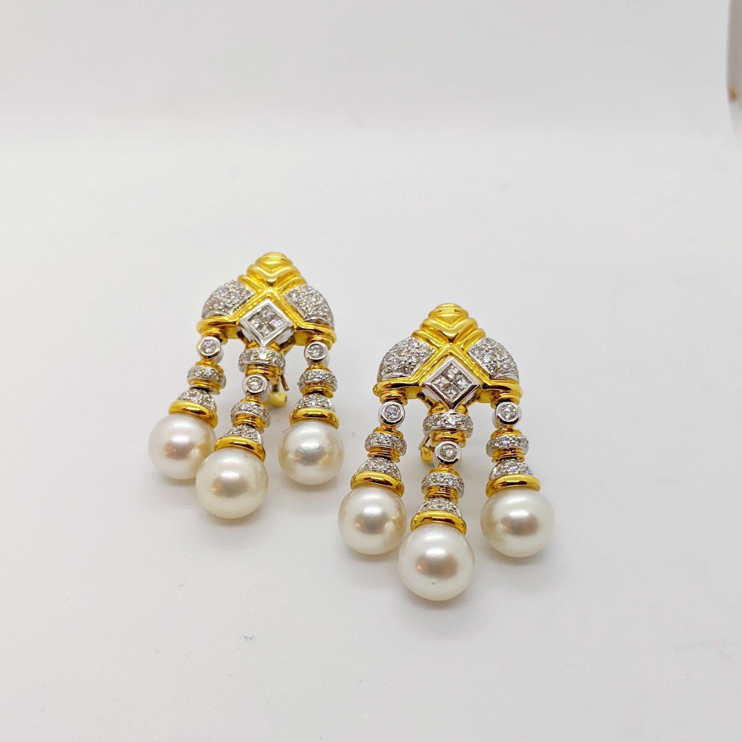 Queen for a day in these regal pearl and diamond drop earrings. The earrings are designed in 18 karat yellow and white gold . Each earring features 3 south sea pearls and a combination of round and emerald cut diamonds. The solitaire diamonds are