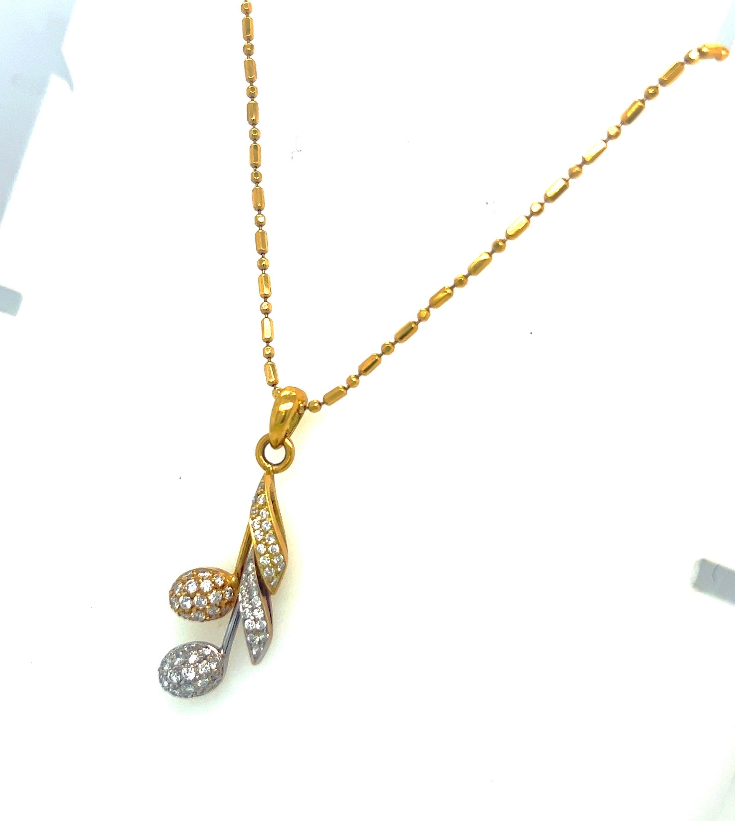 Lovely 18 karat yellow and white gold pendant necklace. The musical note pendant is set with diamonds, total weight of 0.88 carats., and is 1.5