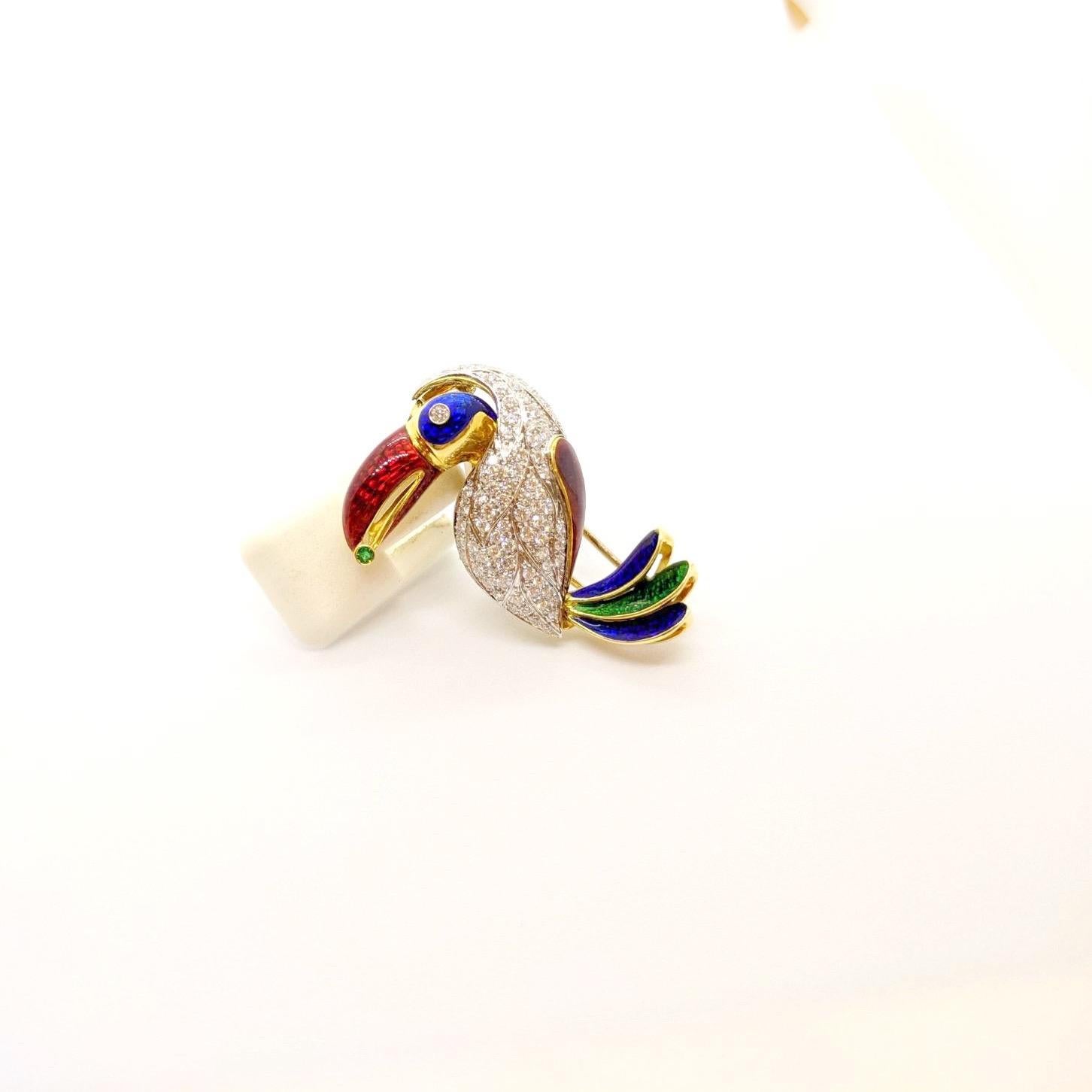 The absolute cutest Toucan. Set in 18 karat yellow and white gold, his feathers are set with round brilliant white diamonds. His eye , beak and tail feathers are crafted with guicholle enamel in red, blue, and green.  He has a bezel set diamond eye,