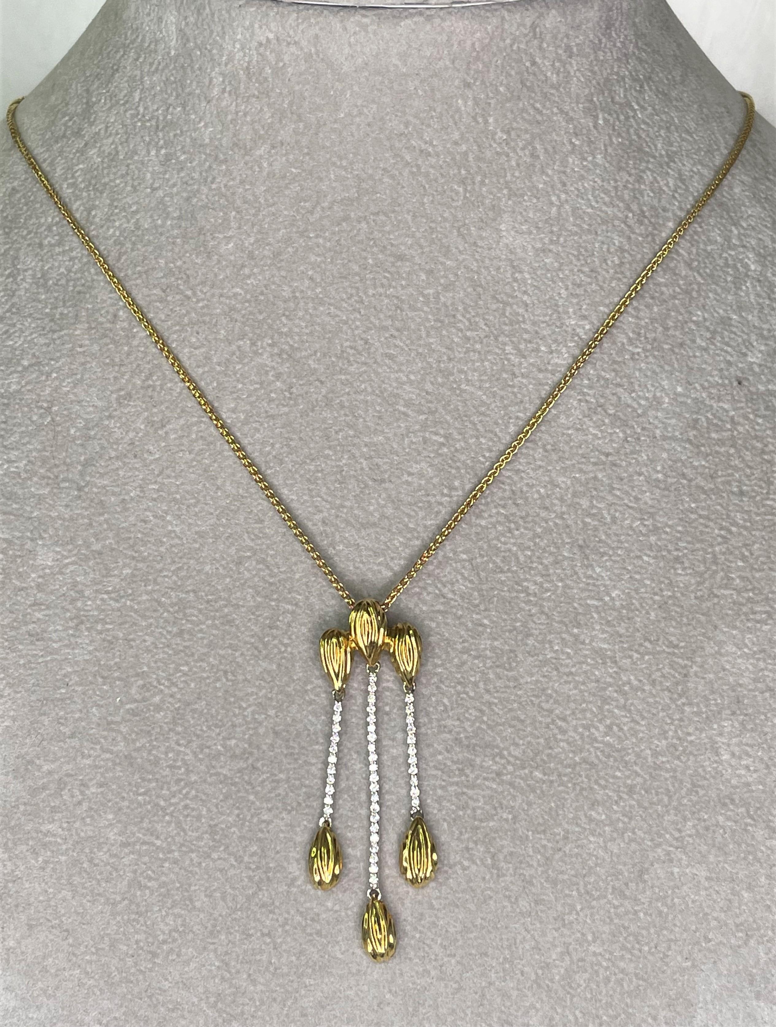This necklace by Spark Creations, is a beautiful easy-to-wear piece that could be dressed up or worn casually!  
18 karat yellow and white gold pendant with three drops, each with a row of diamonds, .31tdw.
Pendant has movement with yellow gold