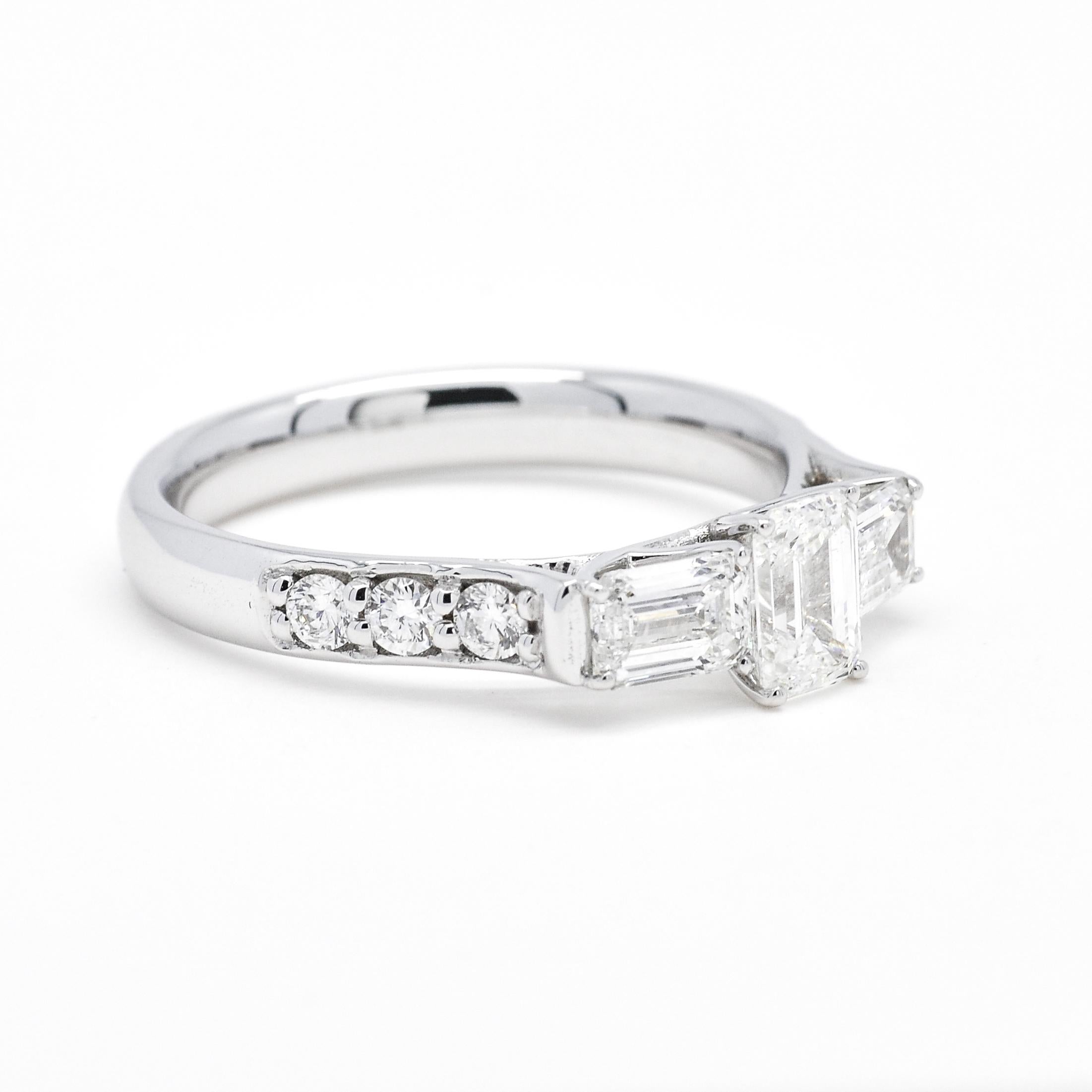 A trio of emerald-cut diamonds radiates a clear and magnificent shine on this stunning engagement ring set with sparkling accent diamonds along the White gold shank.

Elegance re-imagined. A shimmering trio of emerald-cut diamonds are the beautiful
