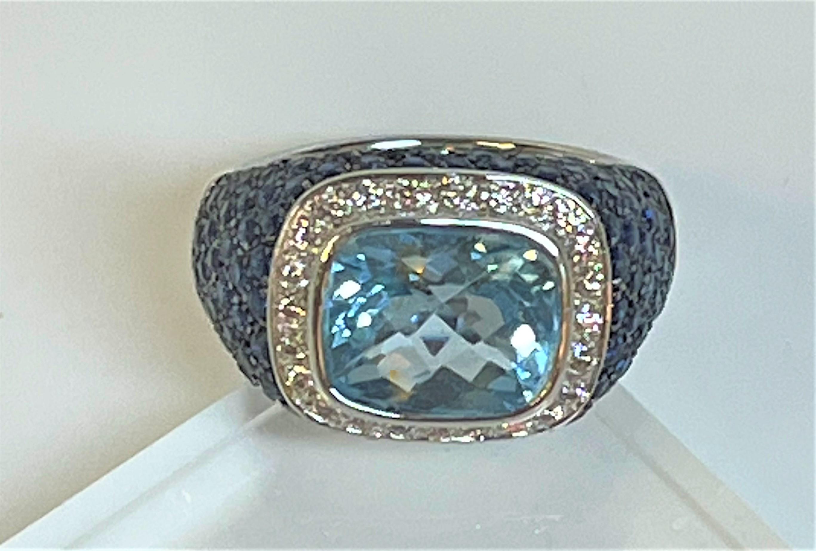 This is a beautiful statement piece!  
18 karat white gold 
Center is a beautiful light blue topaz, approximately 12.5mm x 10mm x 7mm (approximately 6.8 carats).
Center topaz is surrounded by 28 total round diamonds, approximately .02ct each.
Pave
