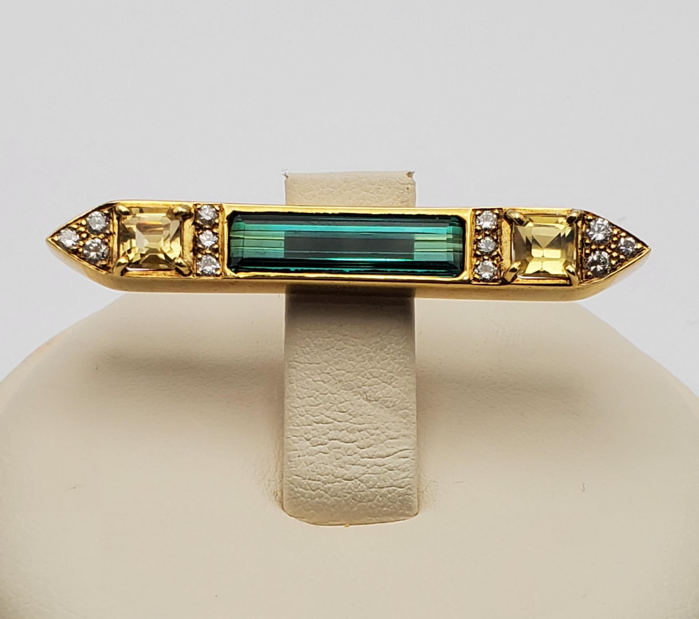 Beautiful and unique modern broach containing an elongated emerald cut, richly colored blue/green  tourmaline, round brilliant cut diamonds and a pair of pale honey-gold colored Asscher cut heliodors (golden beryl). The pin mechanism is a locking