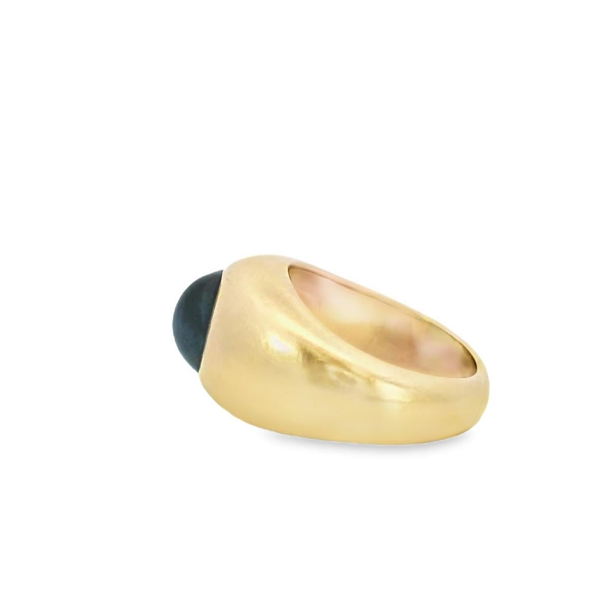 Eine kühne Aussage in Form und Farbton.

Dieser auffällige Ring besticht durch einen blauen Saphir-Cabochon von 3,5 Karat, der in luxuriösem Gold gefasst ist. Der glatte, abgerundete Saphir ist das Herzstück und strahlt eine tiefe, satte Farbe