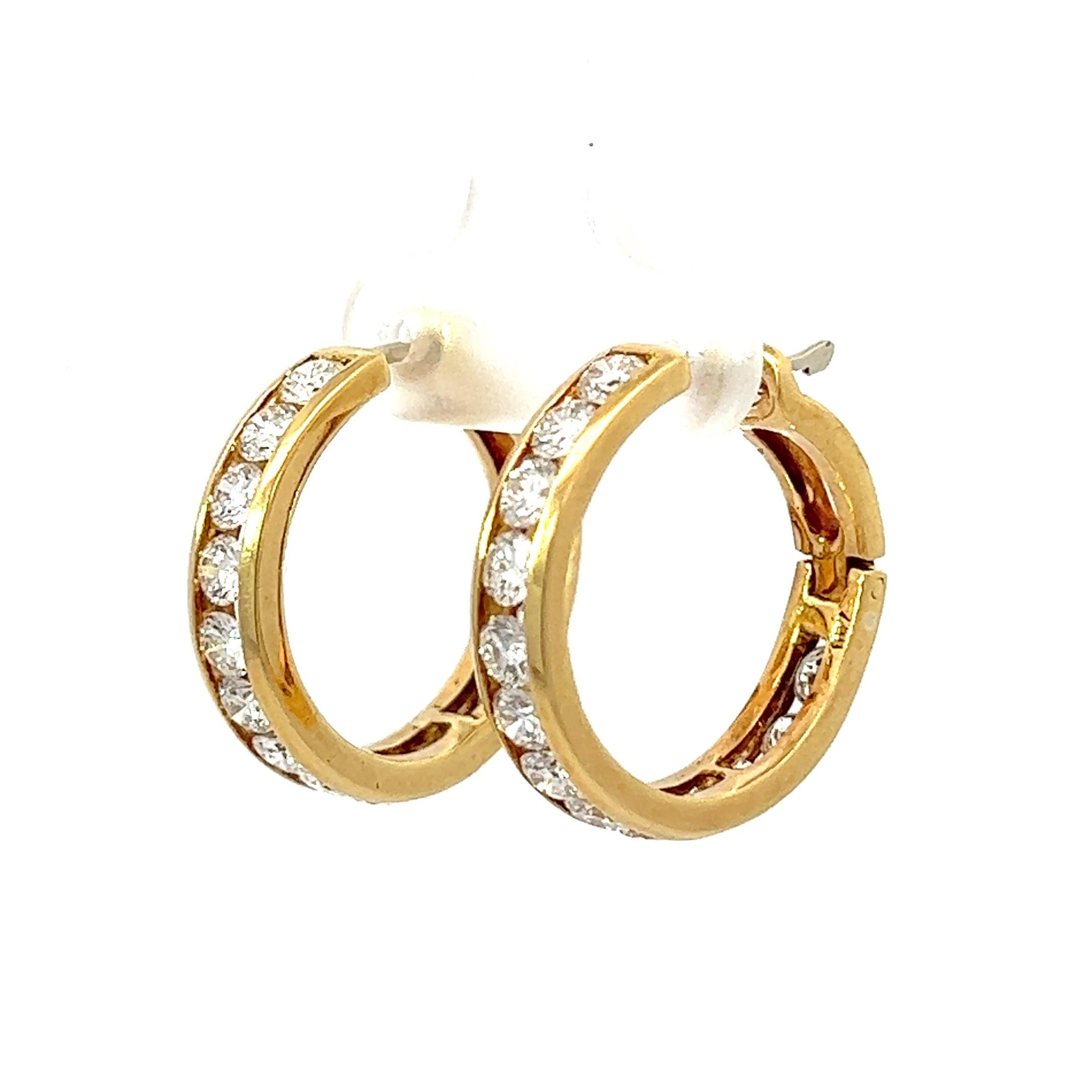 These mini hoops are crafted from 18KY gold and boast a dazzling display of round diamonds at their center. With their sleek yellow gold hue, they are the perfect accessory to elevate any outfit. Make a bold fashion statement without uttering a