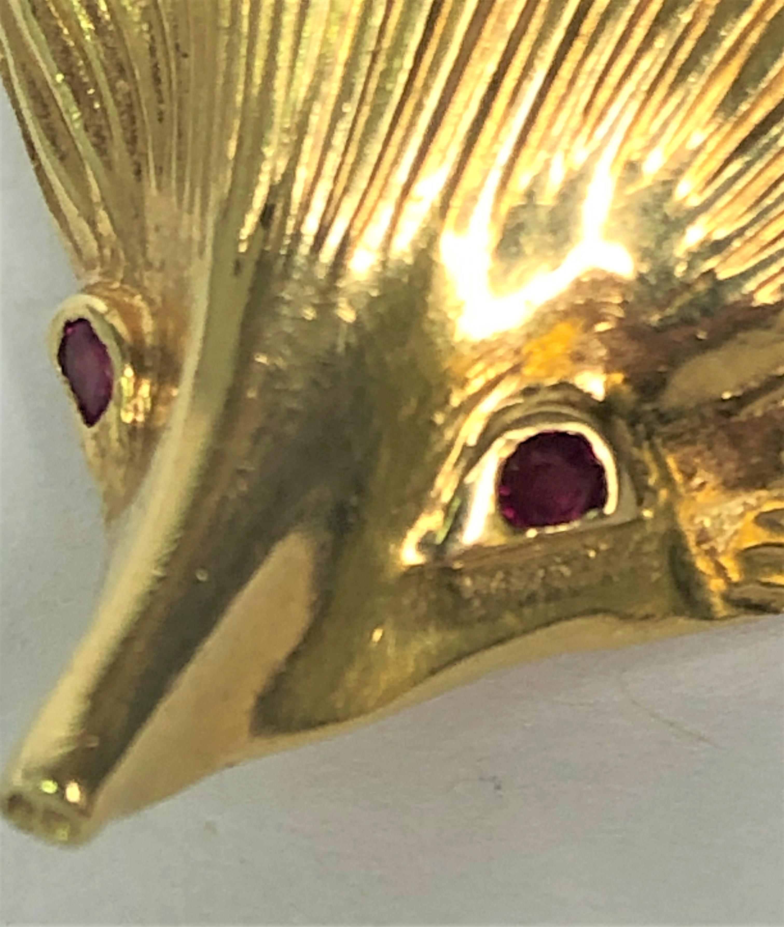 This pokey guy has lots of character!  Perfect for any outfit and a great conversation starter!
18 karat yellow gold porcupine.
Two small round ruby eyes.
Brooch measures approximately 42.5mm x 30mm.
Hinged pin with safety clasp, lays horizontal to