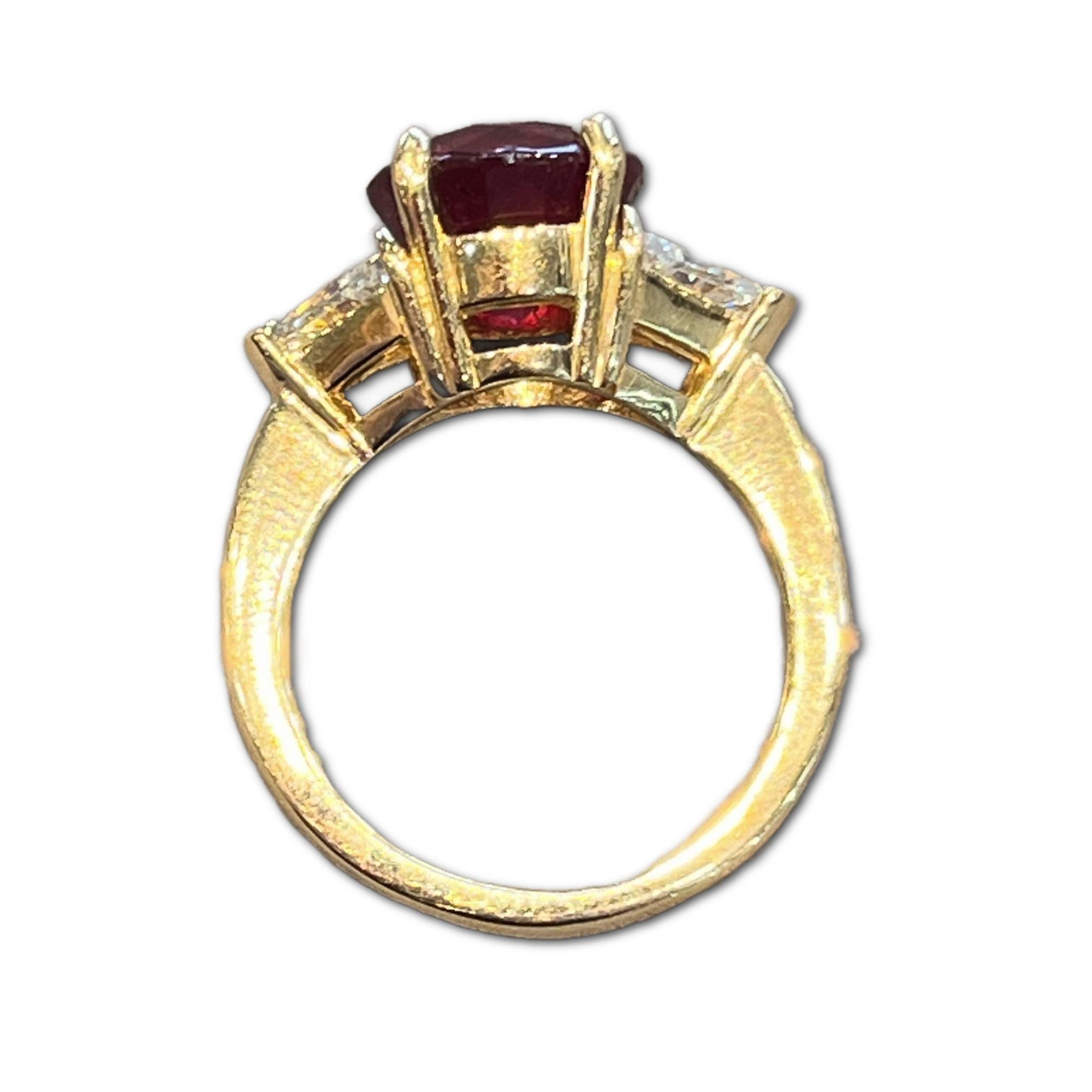 18k Yellow Gold Ruby & Diamond Lady's Three (3) Stone Ring. This Ring Contains One (1) Round Brilliant Cut Ruby Weighing 4.85cts in Total Carat Weight. This Stone Measures Approximately 9.4mm x 9.4mm x 6.5mm. This Stone is Deep Vibrant Red in Color.