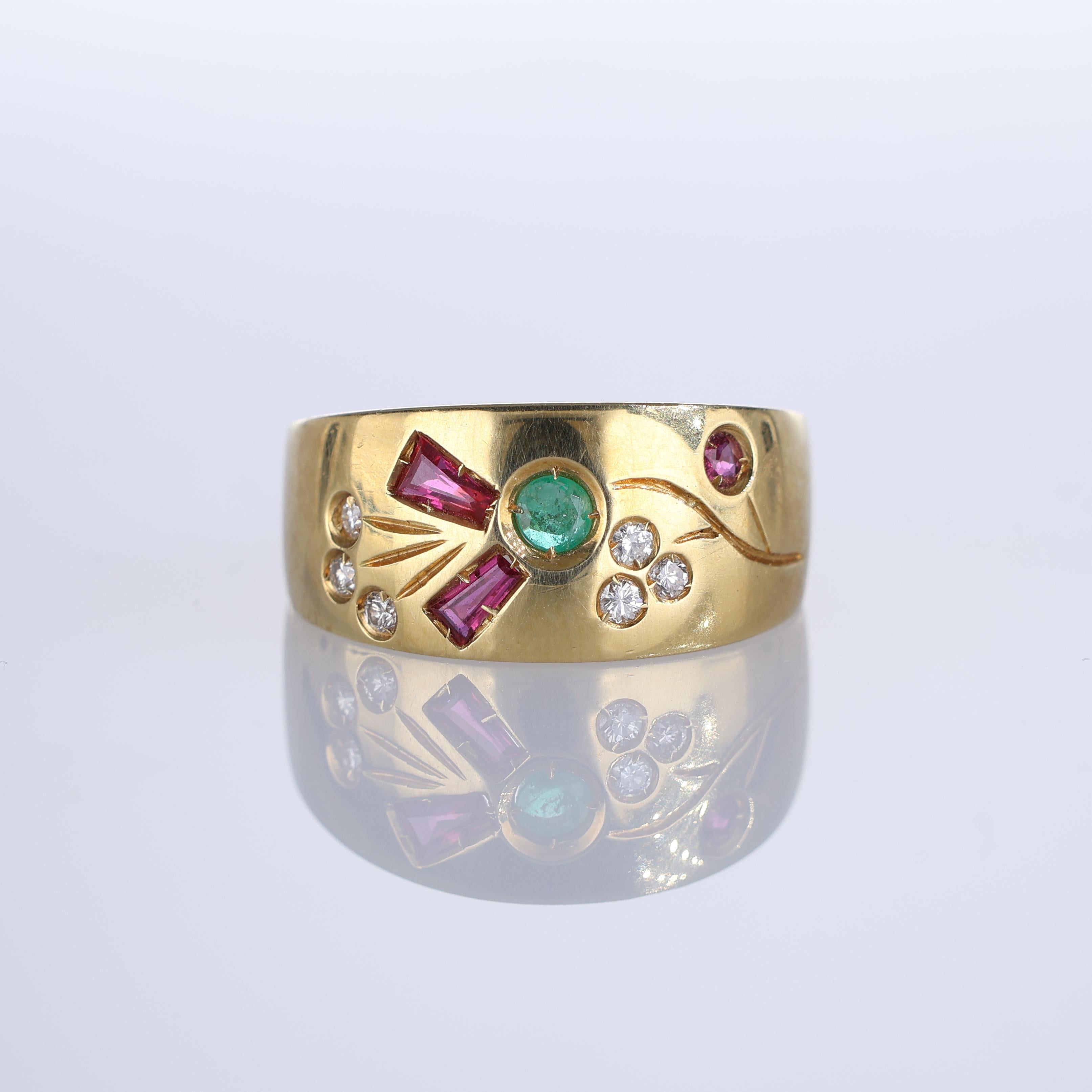 A unique and artistic 18k yellow gold band featuring a floral-inspired inlay of vibrant rubies, emeralds, and brilliant-cut diamonds. The central emerald is framed by baguette-cut rubies, creating a striking contrast, while additional diamonds and