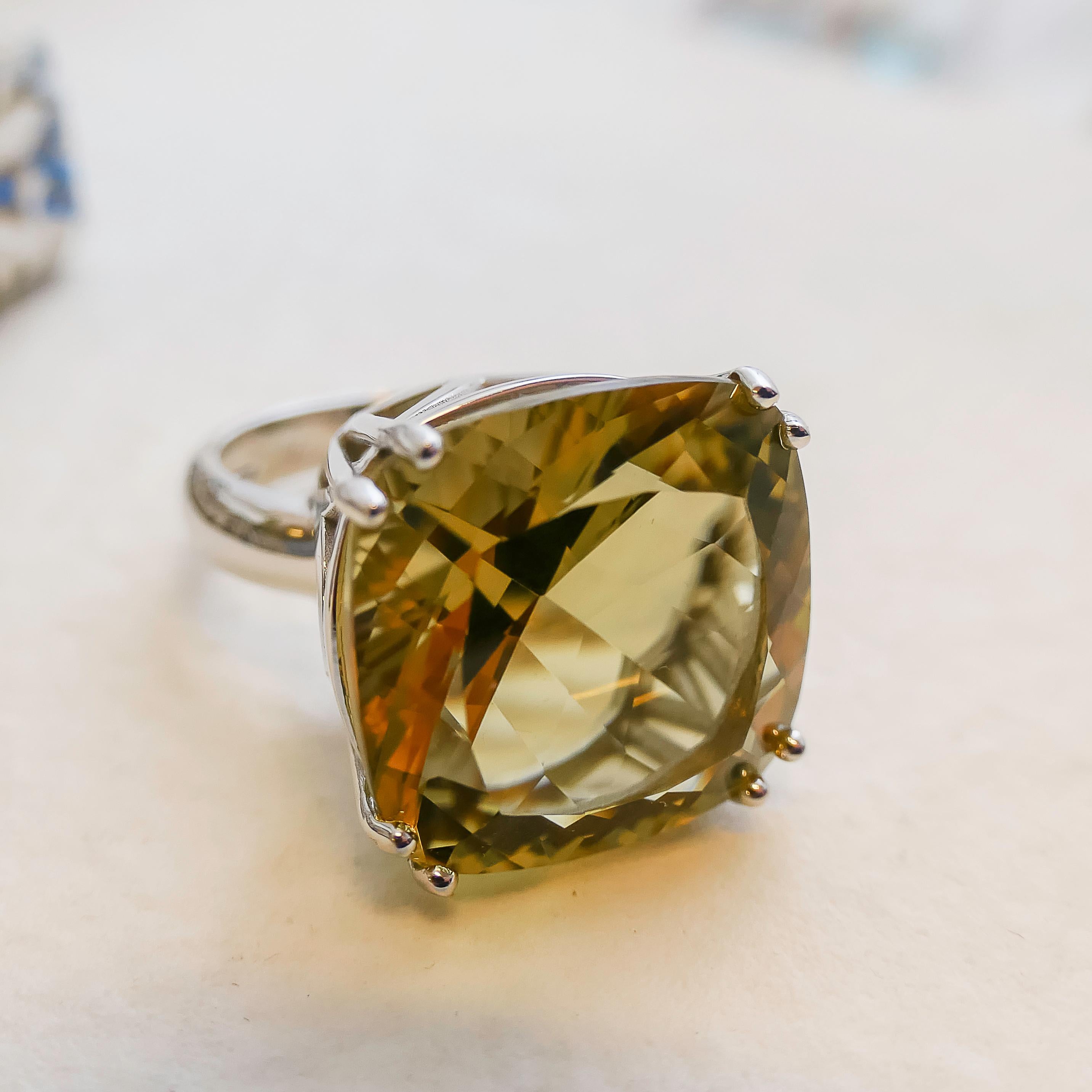 18mm Cushion Cut Lemon Quartz is prong set in sterling silver. Lemon quartz has a bit of brown in it. So it is not a bright yellow color, but a bit more subdued.
This is a high ring as the cut on the stone is deep. Depth is 14mm.

Available in sizes