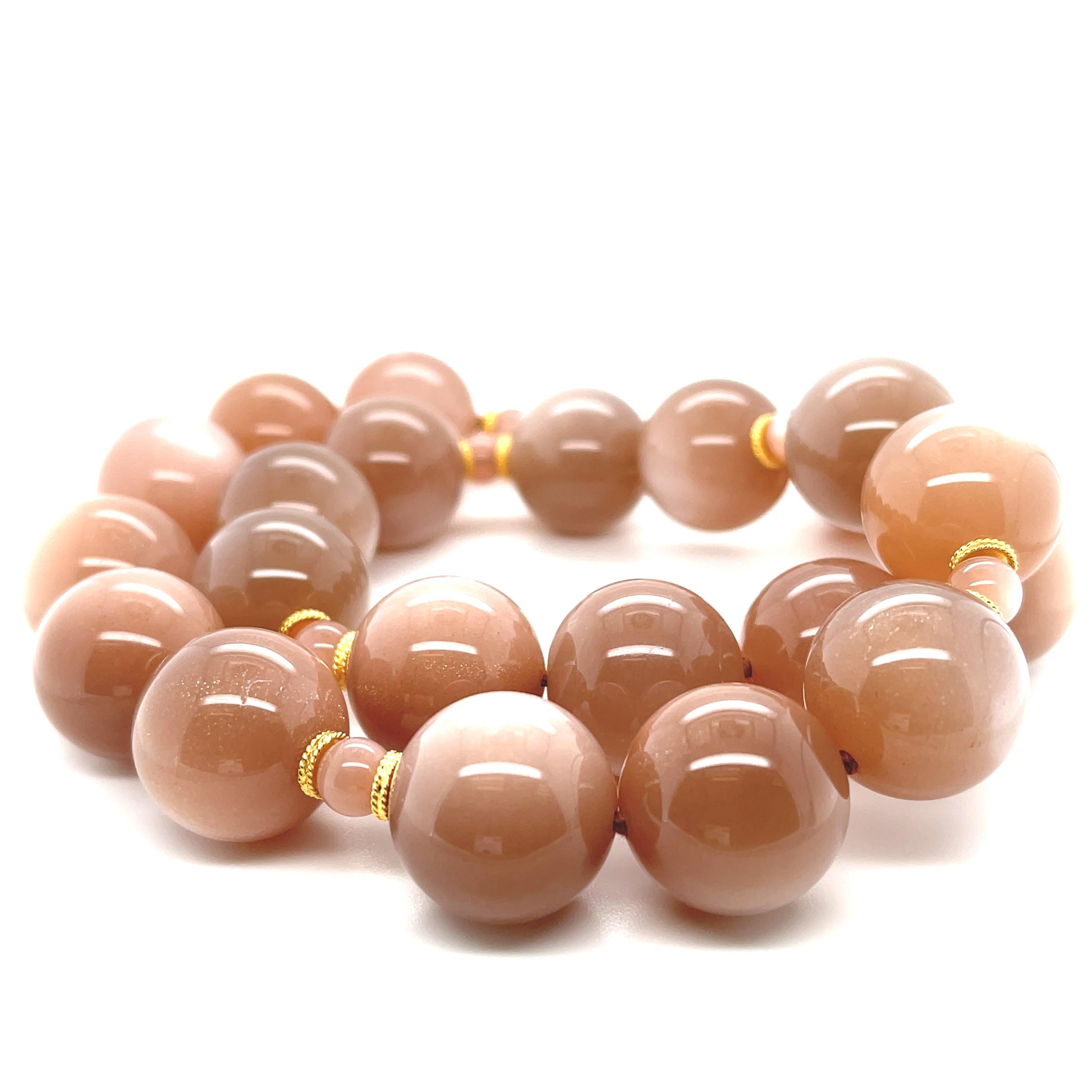 This gorgeous strand of 18mm moonstone beads is so elegant and sophisticated! With beautiful peach-toned body color and shimmering white adularescence that dances across each bead, these gems are a lovely representation of Pantone's 2024 Color of