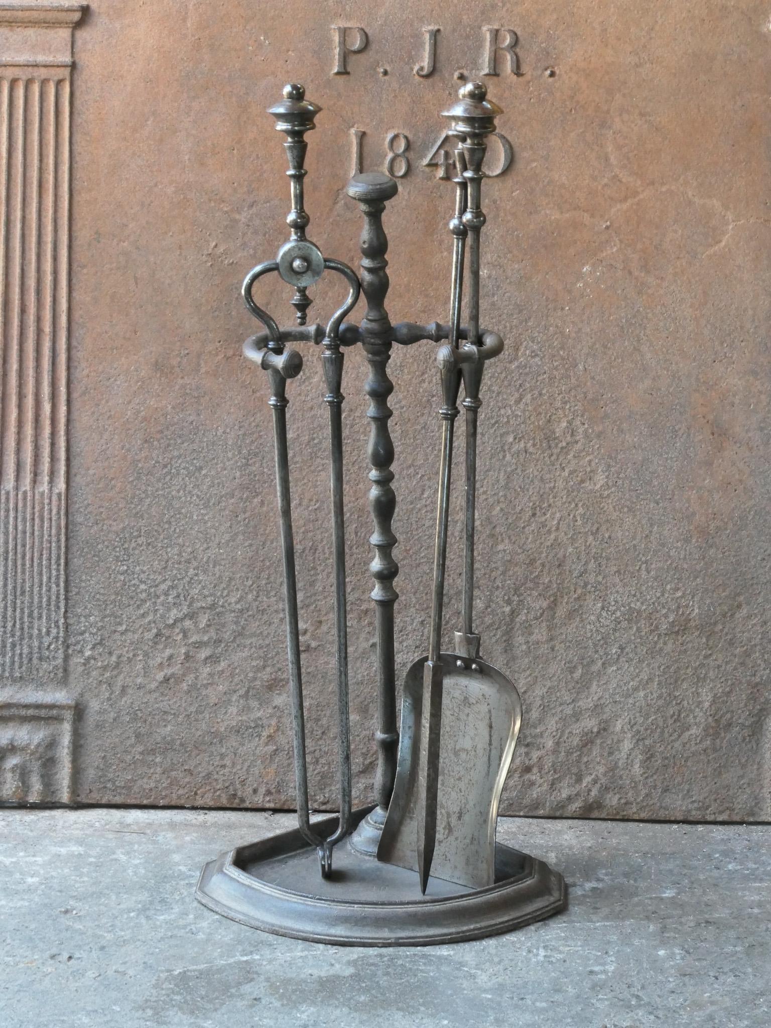 Beautiful 18th - 19th century English Georgian fireplace tool set. The tool set consists of tongs, shovel, poker and stand. The stand is made of wrought iron and cast iron and the tools are made of wrought iron. The set is in a good condition and