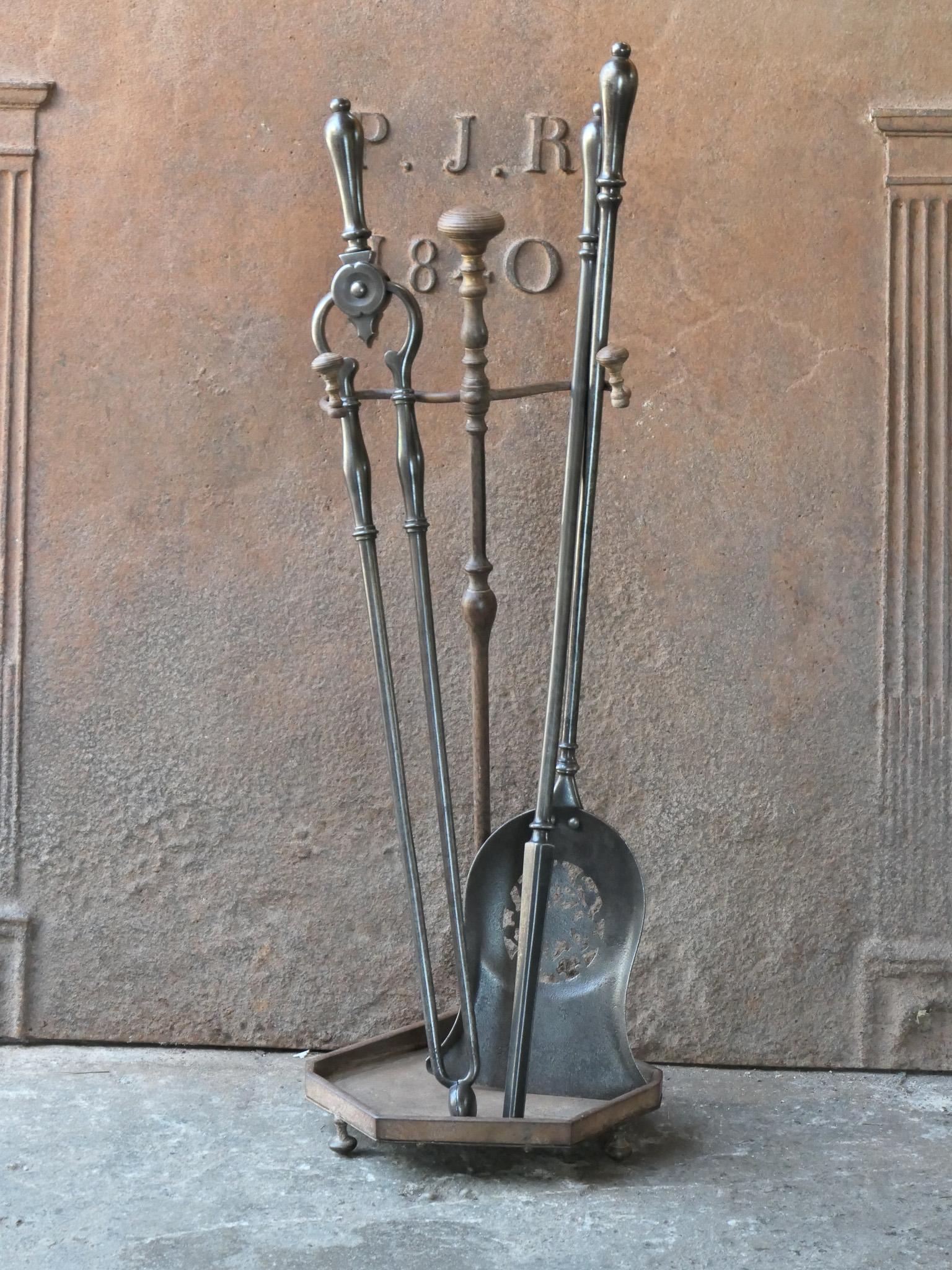 Beautiful 18th - 19th century English Georgian fireplace tool set. The tool set consists of tongs, shovel, poker and stand. The stand is made of wrought iron and the tools are made of polished steel. The set is in a good condition and fit for use in