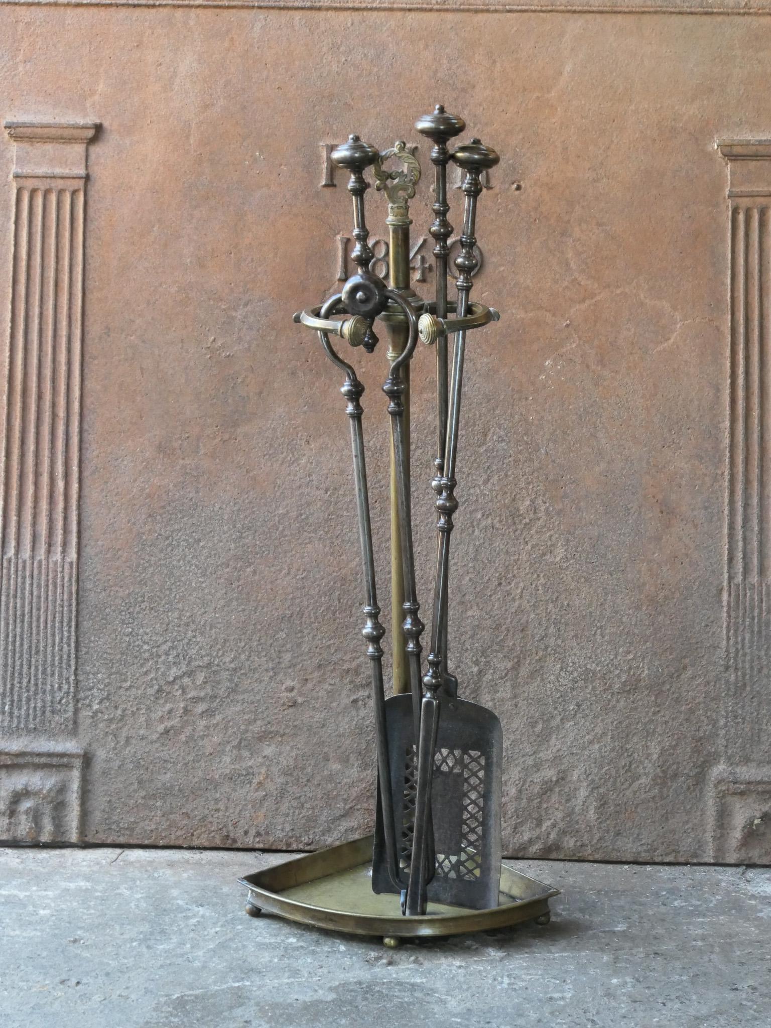 Beautiful 18th - 19th century English Georgian fireplace tool set. The tool set consists of tongs, shovel, poker and stand. The stand is made of brass and the tools are made of wrought iron. The set is in a good condition and fit for use in the