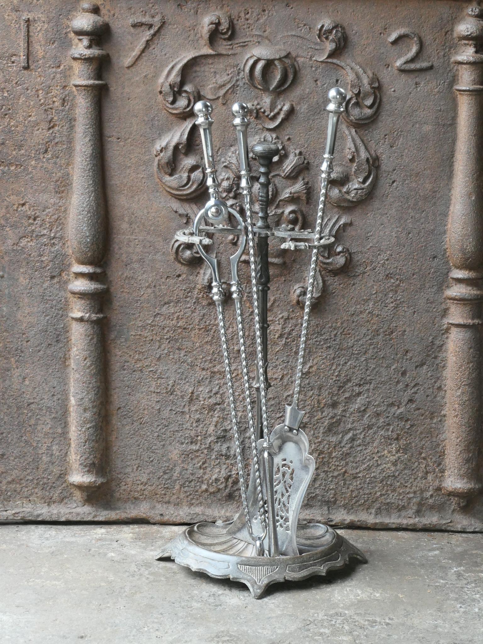 Bel ensemble d'outils de cheminée de style géorgien anglais du 18e - 19e siècle avec de belles décorations. Le set d'outils comprend une pince, une pelle, un tisonnier et un support. Le support est en fonte. Les outils sont en acier poli. L'ensemble