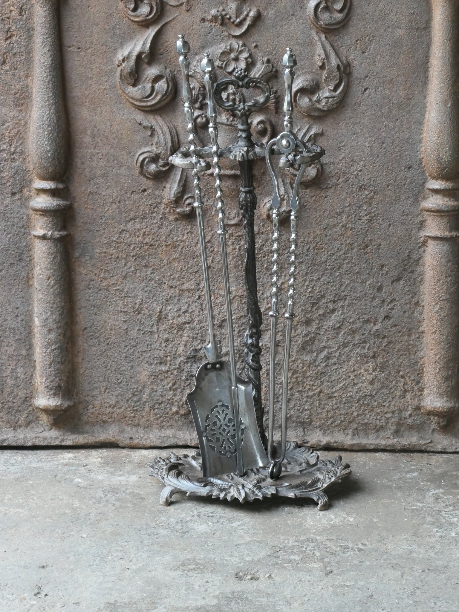 Ensemble d'outils de cheminée géorgien anglais du 18e - 19e siècle. Le set d'outils comprend une pince, une pelle, un tisonnier et un support. Le support est en fonte et les outils sont en acier poli. L'ensemble est en bon état et peut être utilisé