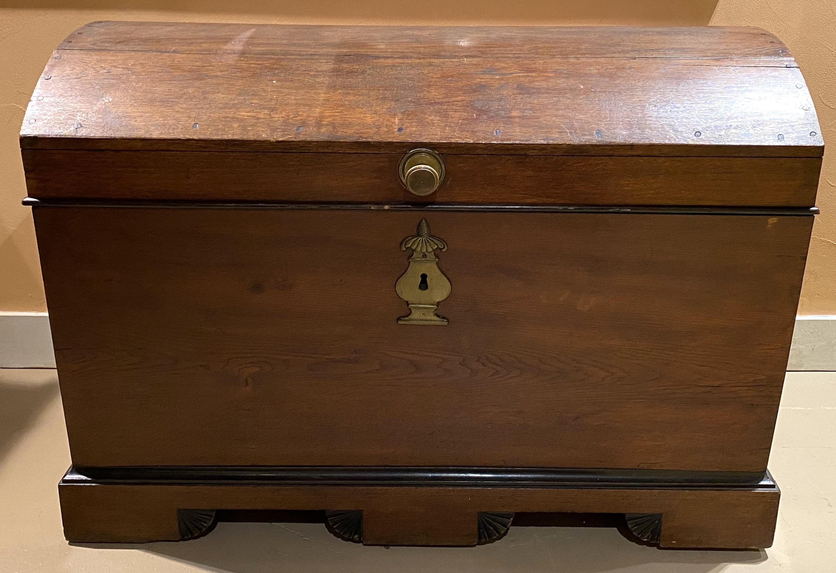 A fine 18th/19th century European oak dome top trunk with original hardware, including iron strap hinges, heavy brass handles and urn form escutcheon, dovetailed and pegged construction, interior till, and shell carved decoration along the base. The