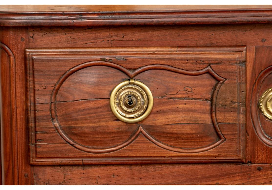 A authentic, very well made and outstanding Provincial French Commode. The top with plank construction and rounded corners. The case with two short drawers over two long ones, all carved. Brass escutcheons and pulls (upper right ring missing).