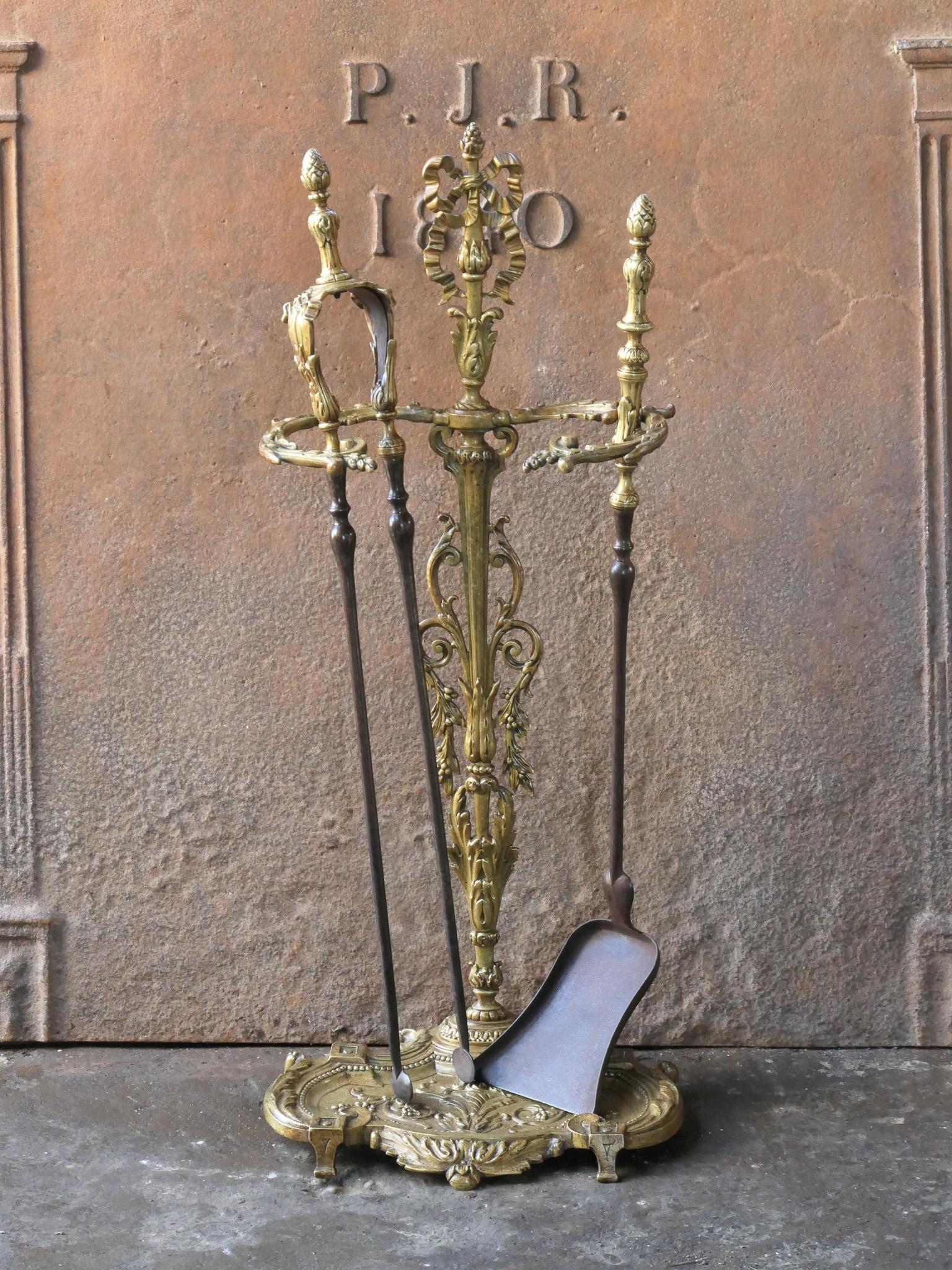 Ensemble d'outils de cheminée néoclassique français des XVIIIe et XIXe siècles, richement décoré. L'ensemble d'outils se compose d'une pince, d'une pelle et d'un support. Le support est en laiton et les outils en fer forgé avec décoration en laiton.