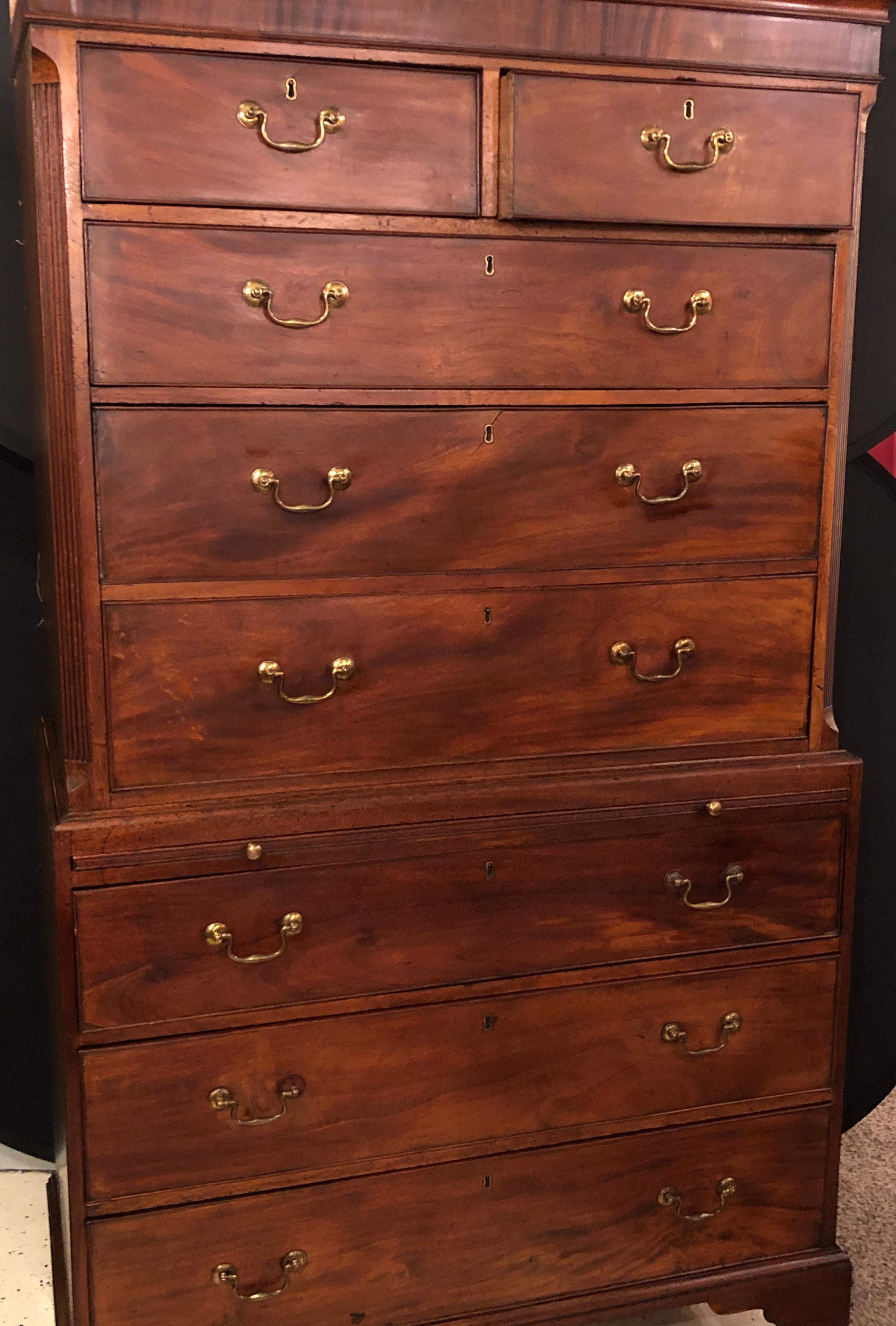 18th-19th century antique English chest on chest, dresser of hi chest. The upper section with dentil molding above 2 half drawers and 3 graduating drawers sitting upon a commode base. The commode chest with a pullout writing table or serving slide