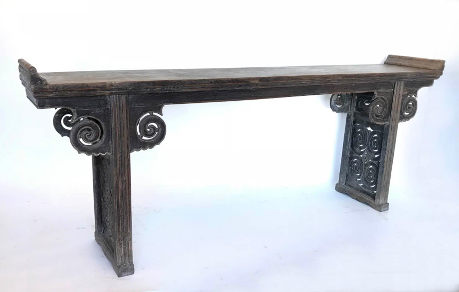 18th-19th century temple altar table from China. Elm wood with intricate carvings. One wide board top with beautiful naturally worn patina. Remnants of old black finish throughout piece, smooth to the touch. Original nails. Back and front are