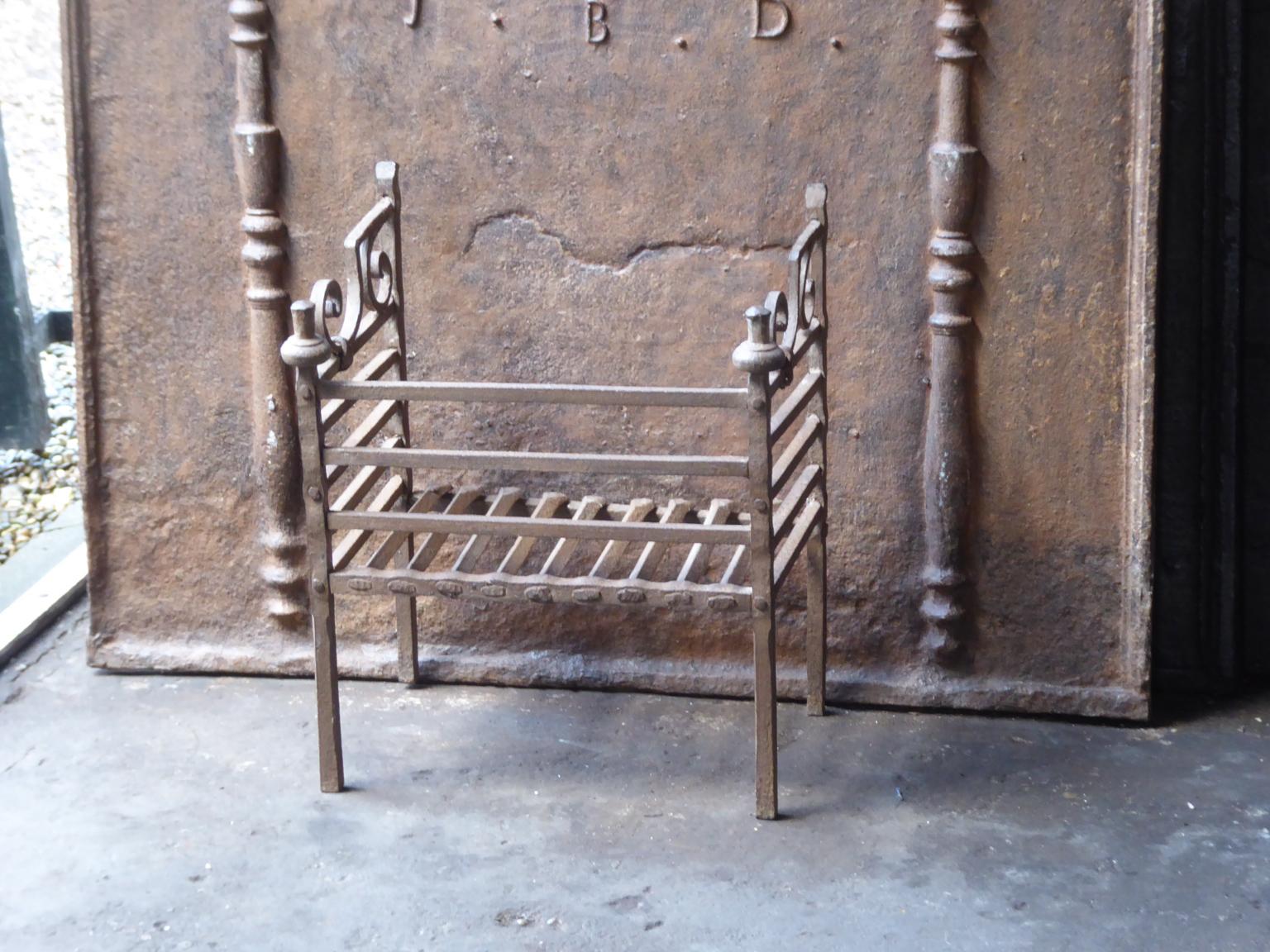 18th-19th century Dutch neoclassical fireplace grate made of wrought iron. The fireplace grate is in a good condition and is fully functional.