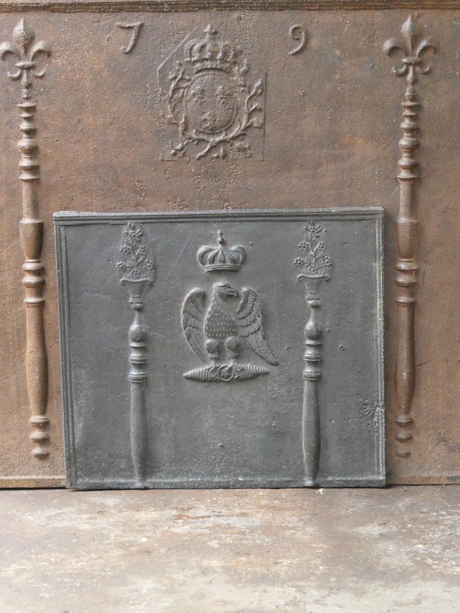 18th-19th century French fireback with two eagles, coat of arms of Napoleon Bonaparte. The style of the fireback is Neoclassical and it is from that period.

The fireback is made of cast iron and has a black patina. The fireback is in a good