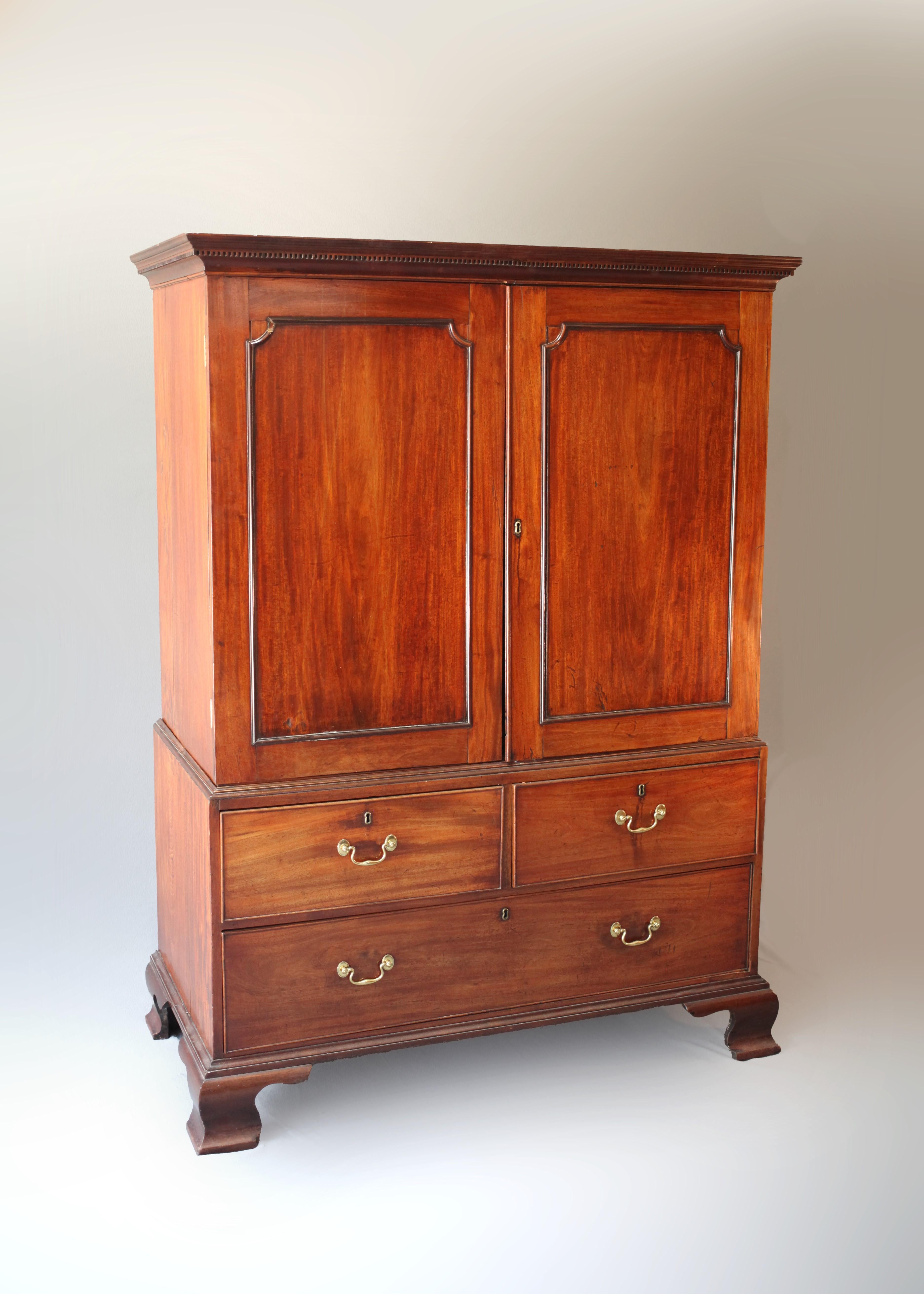 An embodiment of elegance and functionality, this late 18th-century George III Chippendale Linen Press makes an enthralling addition to any collection. This impressive piece, crafted from rich mahogany, features an upper case with a sophisticated