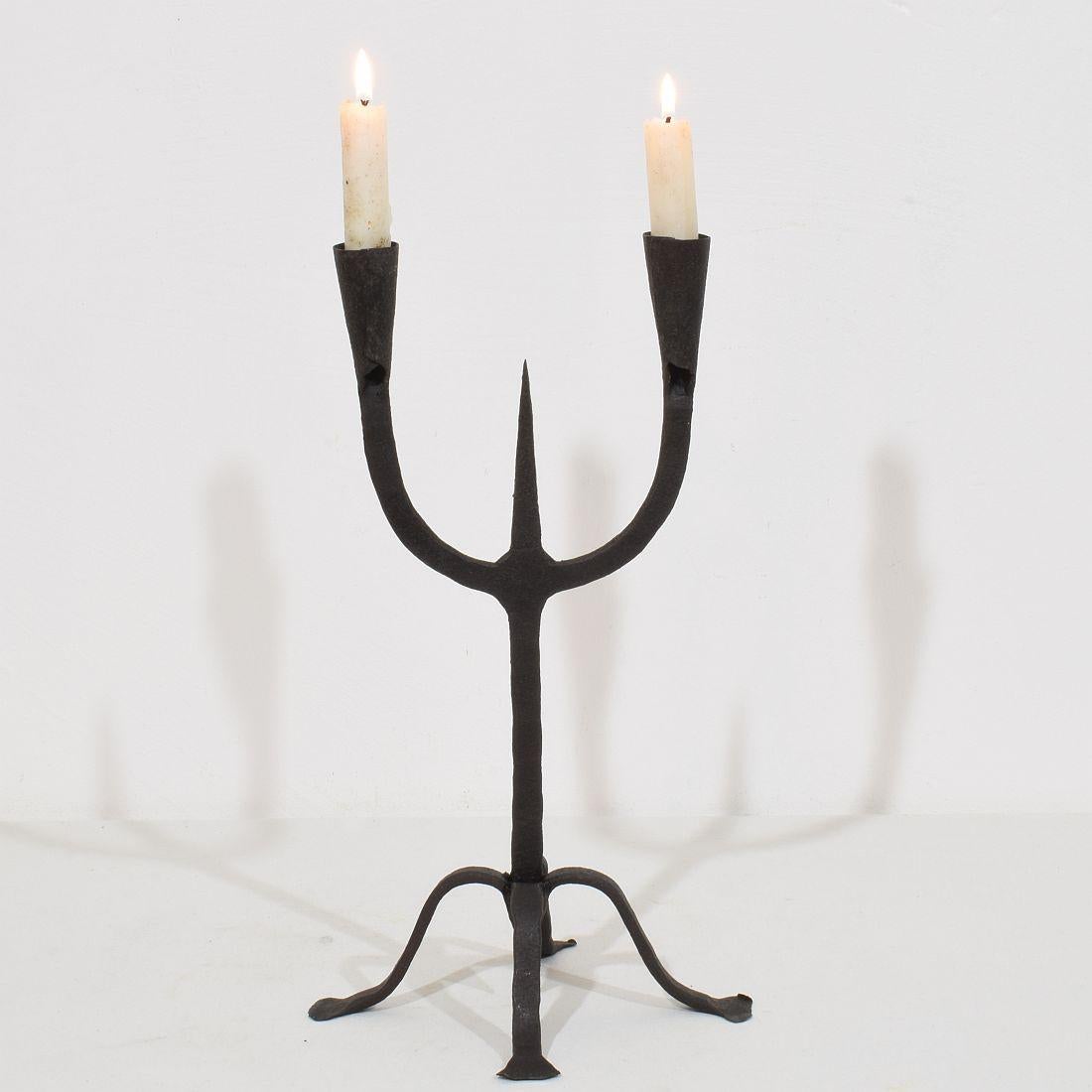 Beautiful 18th-19th century hand forged iron candleholder. A wonderful example of primitive folk art. A perfect balance between utility and aesthetics. 

Southern France, Spain, 18th-19th century. Weathered.