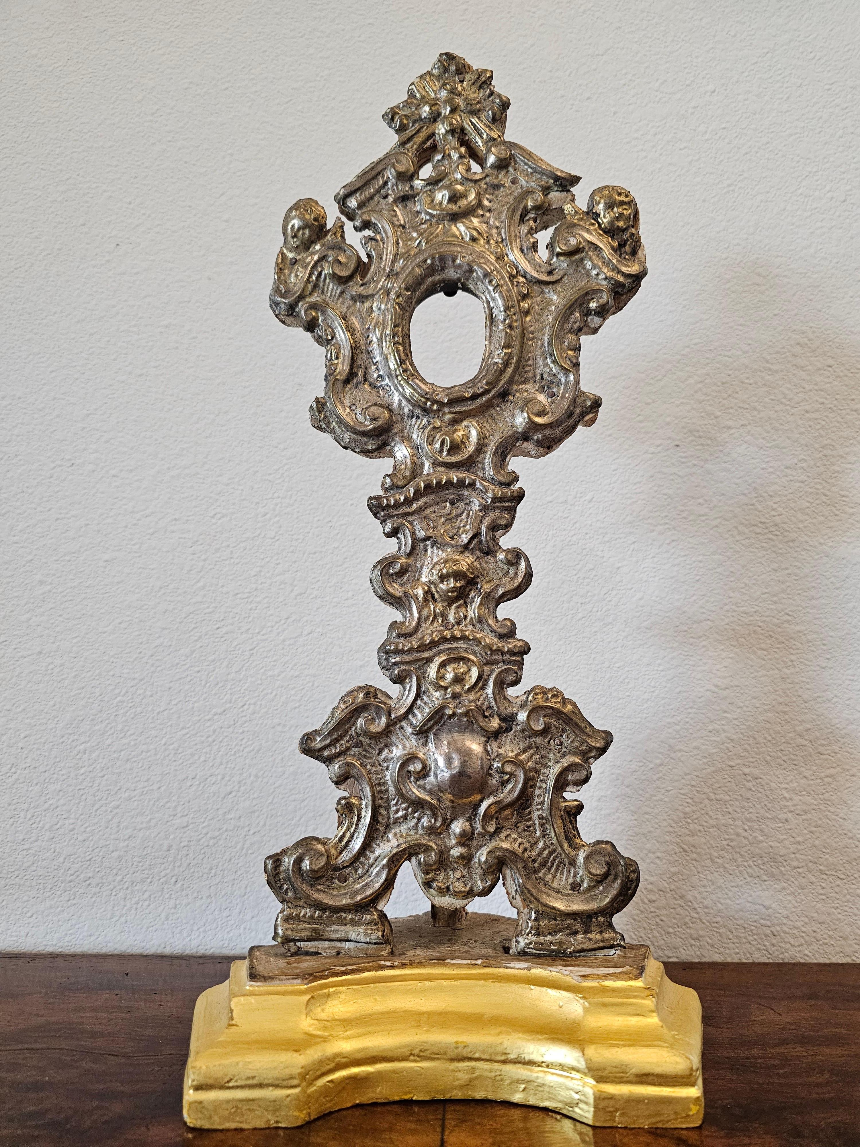 Superbe reliquaire ancien de style baroque italien en métal argenté et bois doré. Vers 1770-1820.

Fabriqué en Italie à la fin du XVIIIe siècle / début du XIXe siècle, sur commande de l'église pour exposer une importante relique religieuse, forme