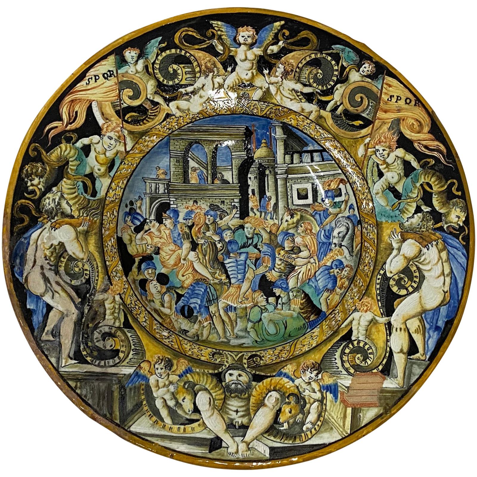 19th century Italian Majolica dish with Renaissance figures

Superb highly decorated Italian Majolica plate with hand a hand painted scene of Roman mythology; The abduction of Sabine women. The border shows Classic Renaissance figures such as