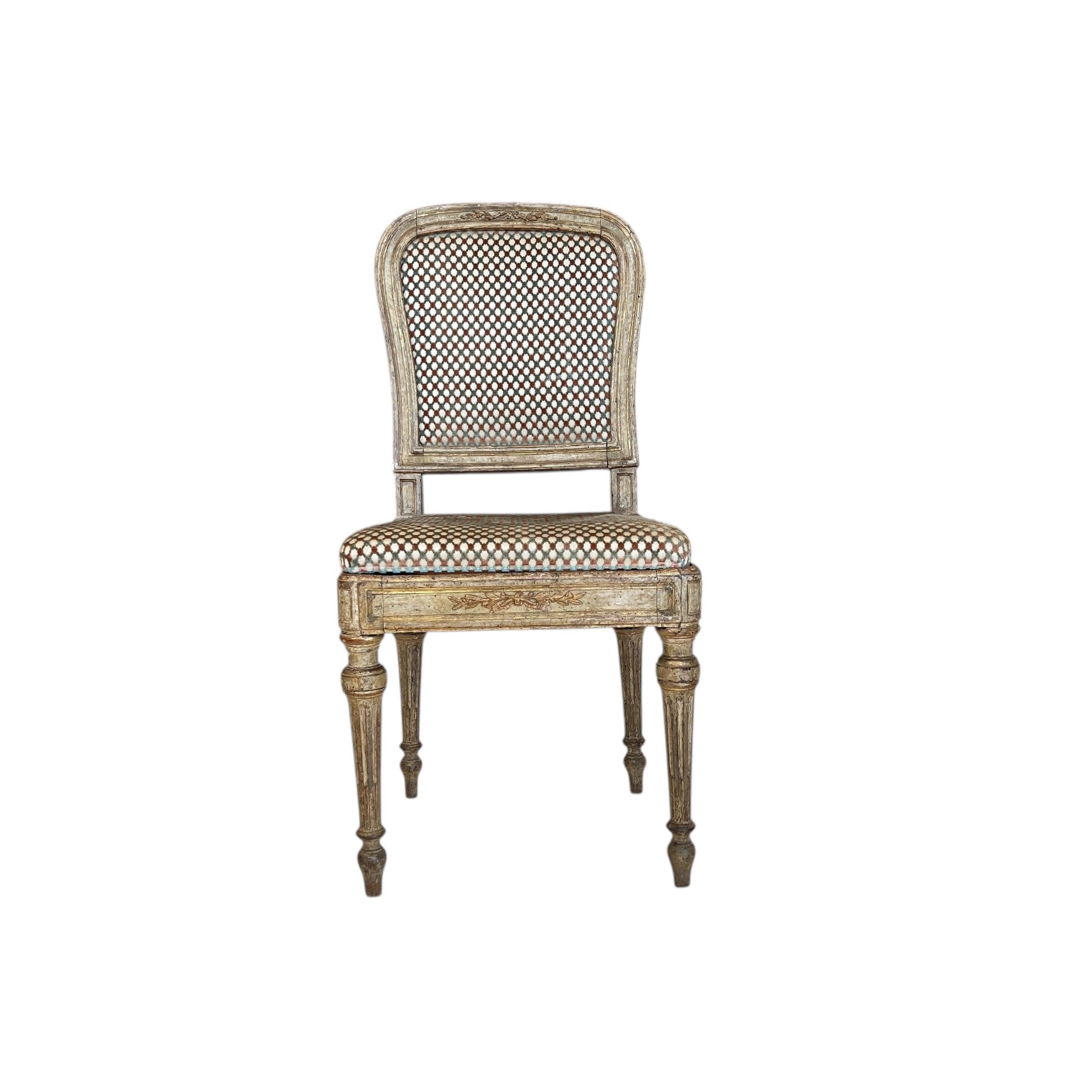 Excepcional juego de 10 sillas de comedor Luis XVI, finamente talladas con patas acanaladas y detalles de roseta, que conservan su acabado original pintado y dorado, ofreciendo una refinada elegancia neoclásica y una rara continuidad para el gran
