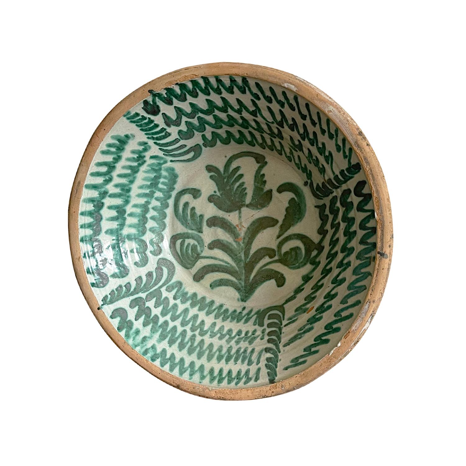 Eine große antike spanische Lebrillo-Mischschüssel aus handgefertigter Terrakotta aus Granada, Spanien. Mit einem Glasurdekor im typischen Morisco-Grün über einer milchweißen Glasur. Auf den Boden der Schale ist ein florales Motiv gemalt, das mit