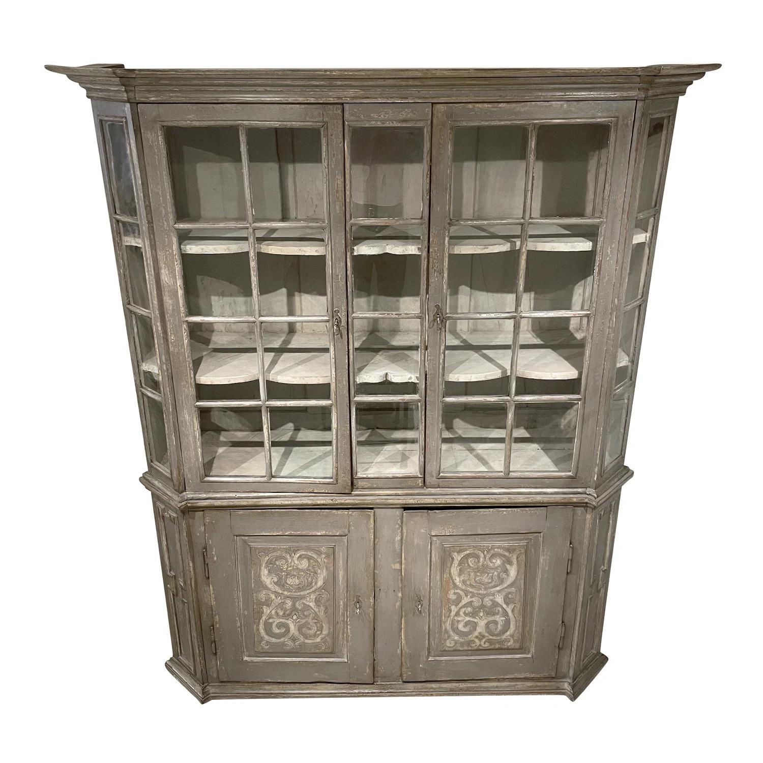A light-grey, antique large Swedish Baroque two-part bookcase made of hand crafted painted Pinewood, in good condition. The upper part of the detailed Scandinavian library, showcase is composed with two doors featuring its original glass and two