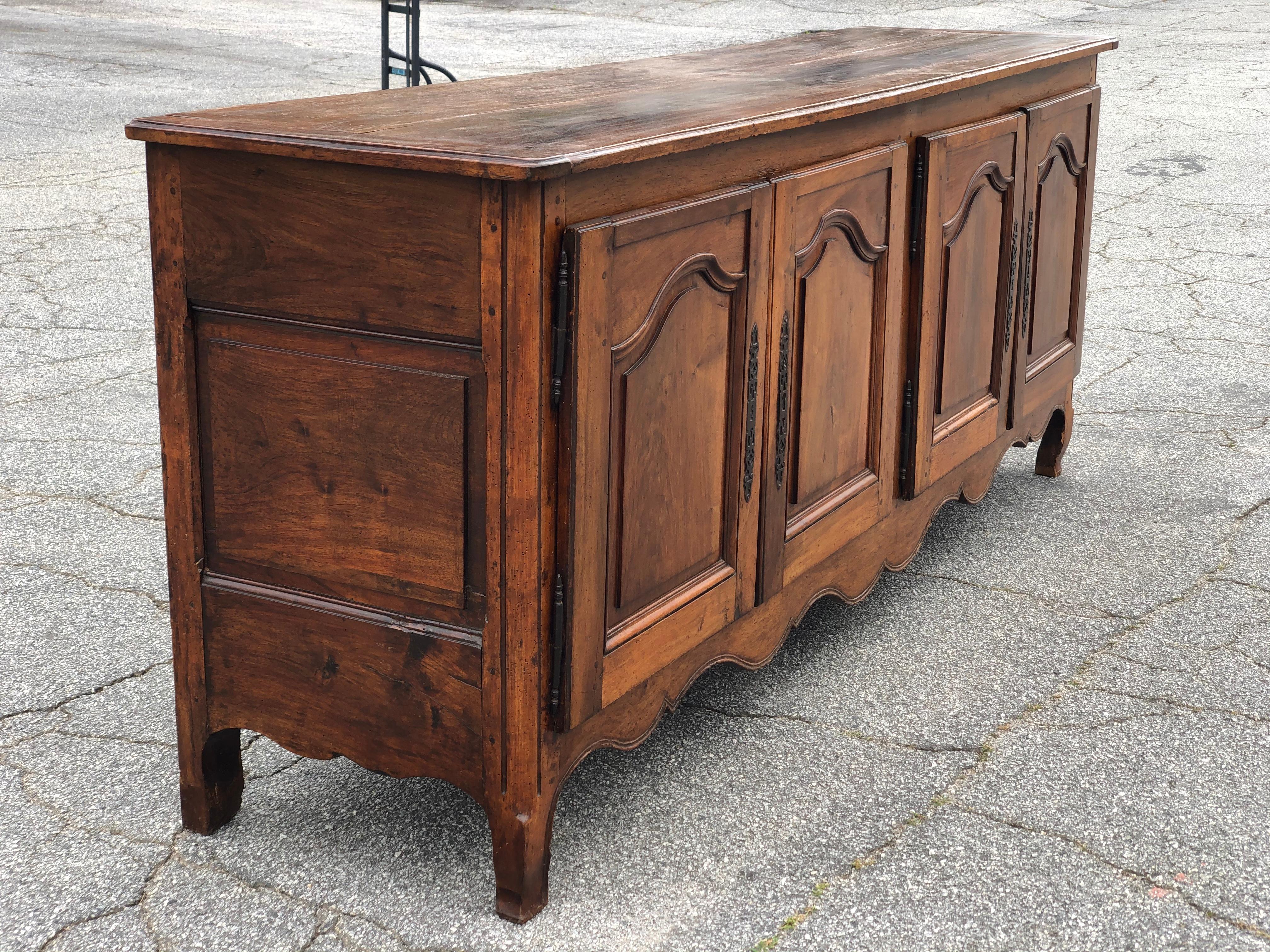 Incredible 18th-19th century French provincial walnut and cherrywood 4 door enfilade. Double pinned mortises throughout, beveled paneled doors, shaped top and carved apron resting on original feet.