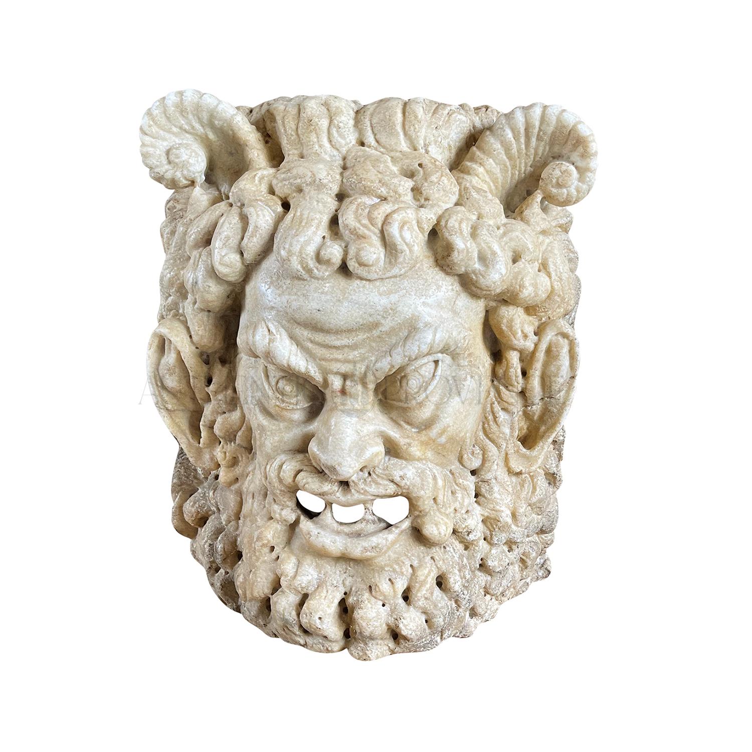 Masque de satyre mythologique en marbre sculpté à la main à la fin du 18e/19e siècle avec des cornes, patine d'usage en bon état. Le fragment de support mural en marbre italien de Carrare, sculpté à la main, a été réalisé de manière très détaillée.