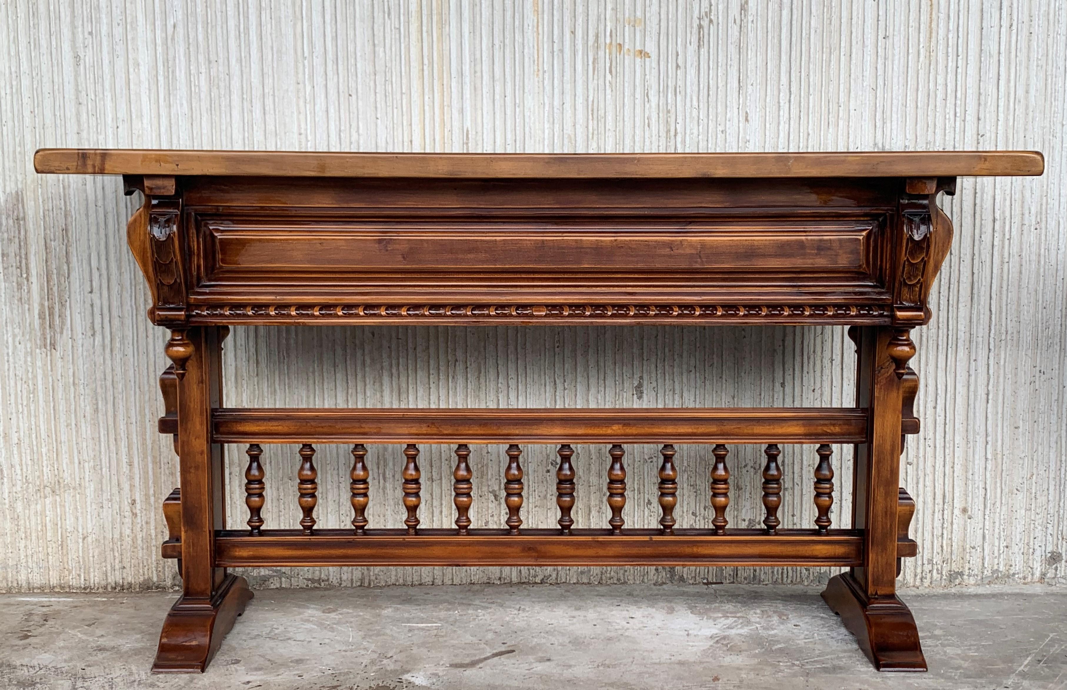 18th century Spanish Baroque console table in walnut with three carved drawers and stretcher.