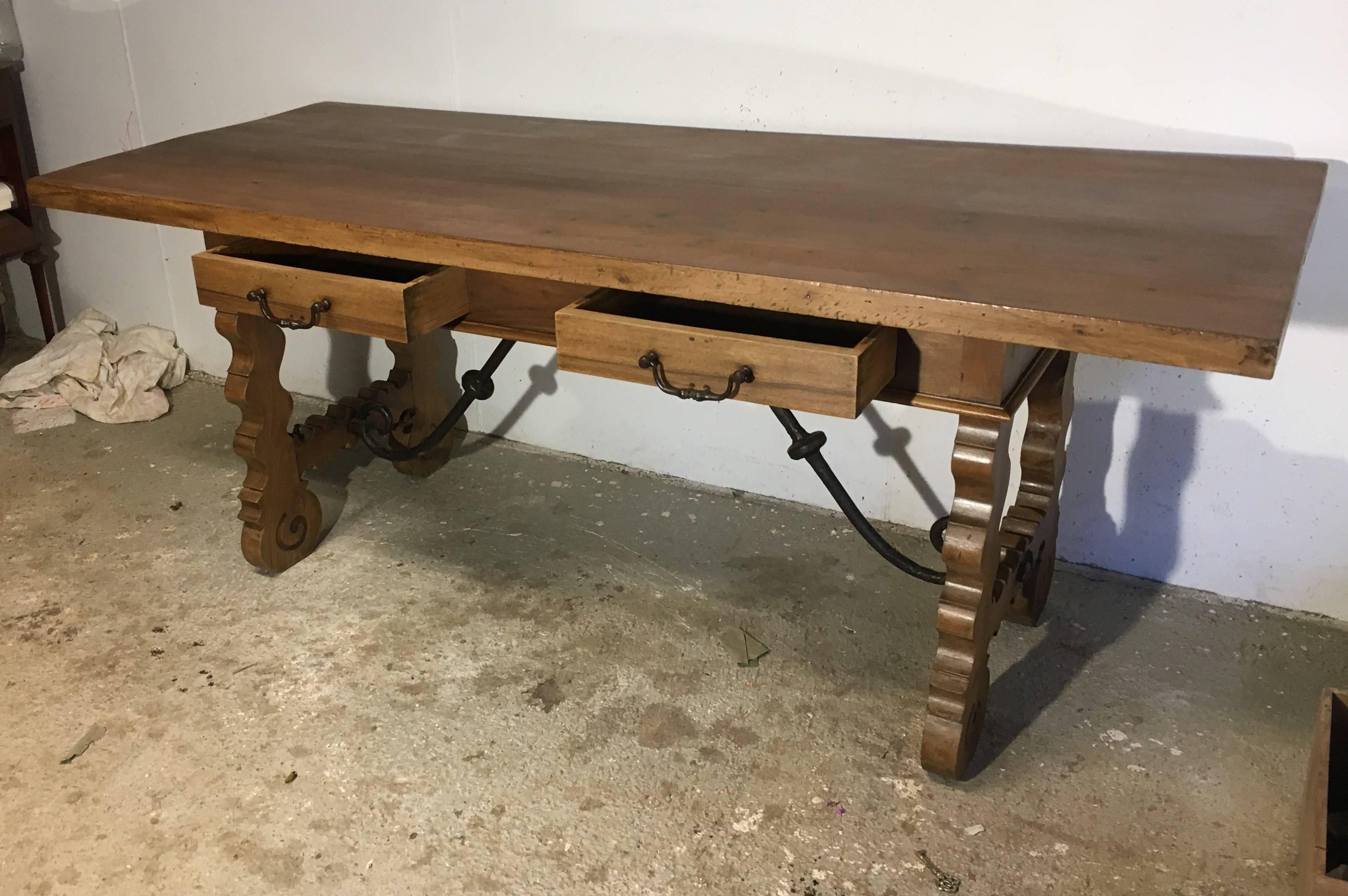 This elegant, antique fruitwood desk was crafted in Spain, circa 1780. The rustic writing table has been stripped down from its original dark finish to a bleached one sealed with clear wax. The table has a top surface secured with four round forged