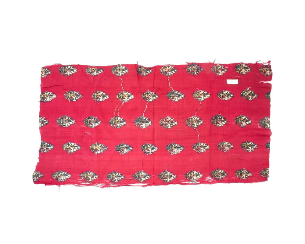 An antique Persian Iranian Safavid hand woven textile fragment, circa 18th century. The textile is decorated with floral motifs on the red background. Safavid Iran or Safavid Persia, also referred to as the Safavid Empire, was one of the greatest