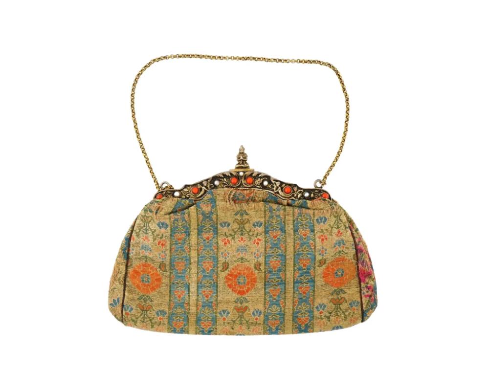 An antique Persian Iranian Safavid hand woven textile hand bag featuring a luxurious and intricate pattern. Circa: 18th century. The textile is adorned with vertical stripes of blue and gold, interspersed with floral motifs. The frame of the bag is