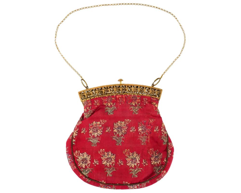Sac à main antique en textile persan iranien Safavide tissé à la main avec des poches à l'intérieur, vers le 18e siècle. Le textile est décoré de motifs floraux sur fond rouge. Le cadre du sac est doré et orné. Une délicate chaîne en or lui sert de