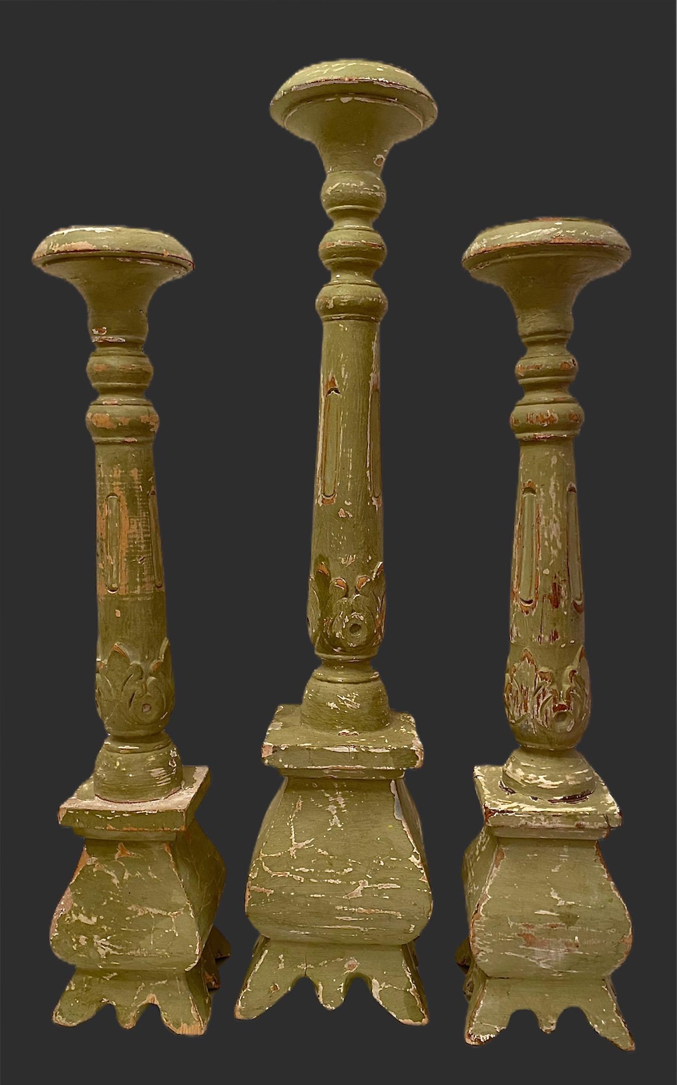 Set of three antique Austrian 18th century chalk painted candlesticks. A pair and a taller one. Each candlestick or altar stick is slightly different as they are hand carved. The tall one measures approx. 21 5/8