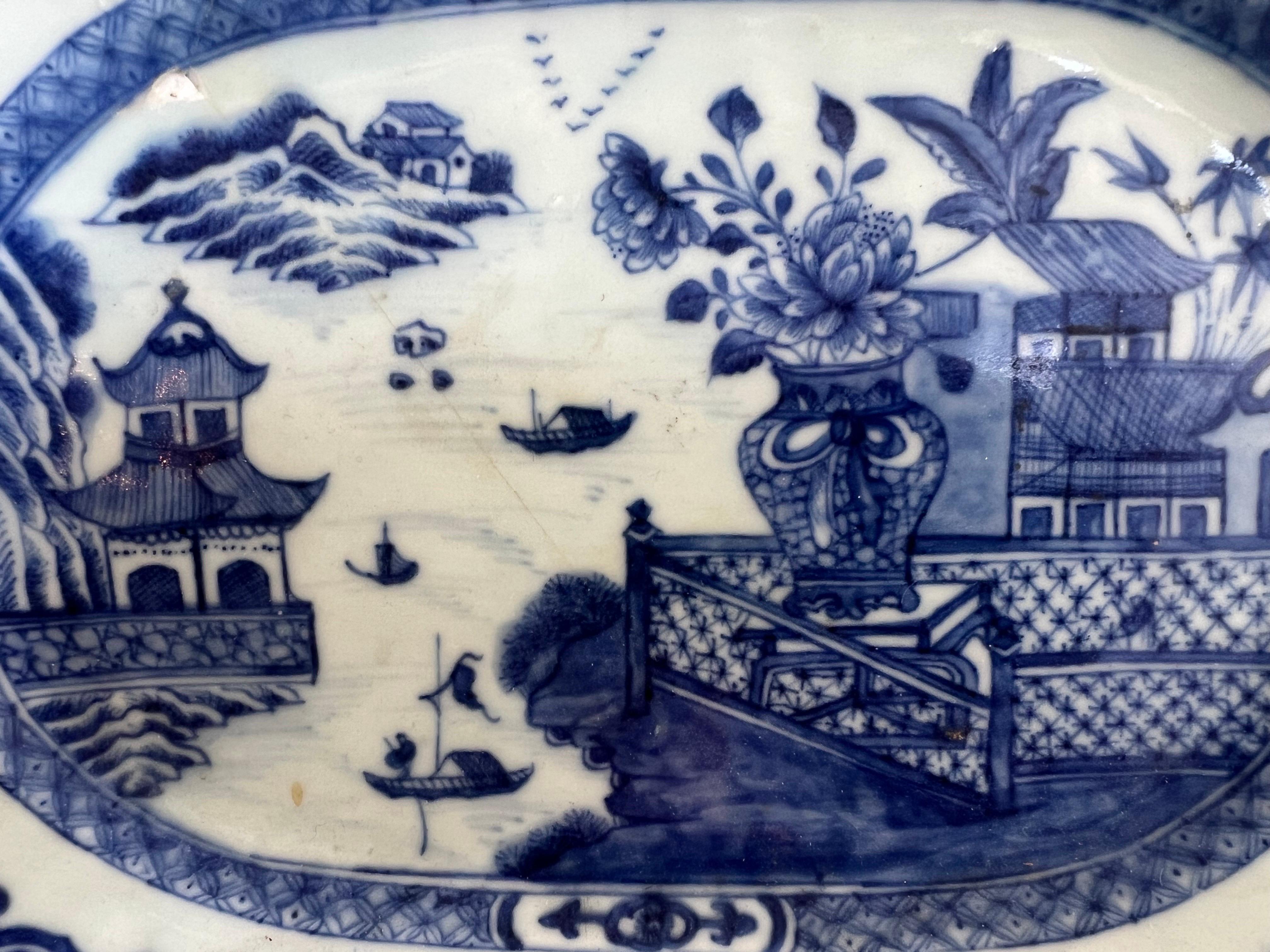 Assiette octogonale d'exportation chinoise du XVIIIe siècle présentant un captivant motif bleu et blanc.  Les scènes complexes représentent des pagodes, des fleurs, des scènes de la vie quotidienne, des lacs, des bateaux, mettant en valeur l'art de