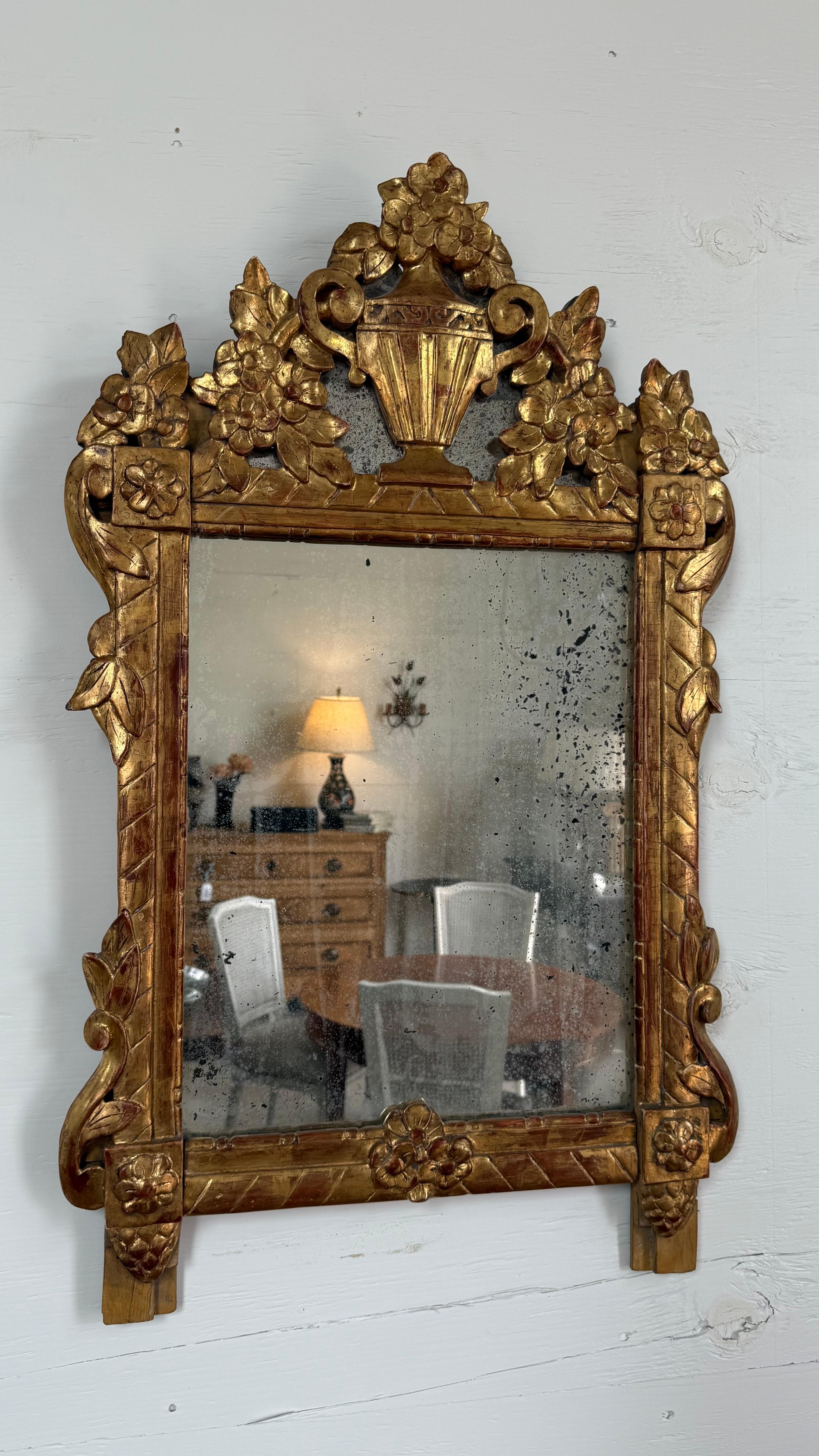Superbo esempio di artigianato francese del XVIII secolo, questo specchio matrimoniale in legno dorato squisitamente intagliato è un pezzo raro ed elegante, ricco di arte e tradizione. Originario della Francia, lo specchio era originariamente un