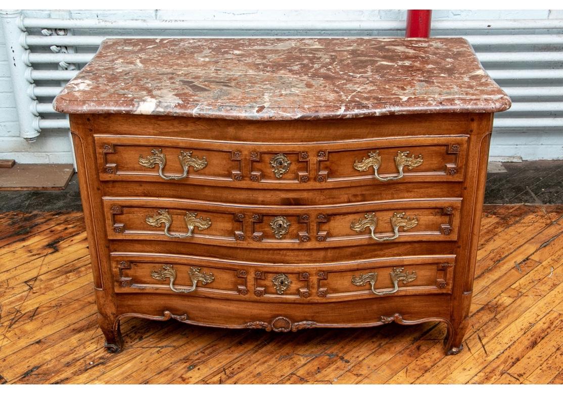 A shaped case with three long drawers carved with angular frames with rosettes. Each with new added compartments. Carved side panels, carved lower frame with leafy vines raised on carved shaped legs. With fine Baroque brass hardware. The drawers